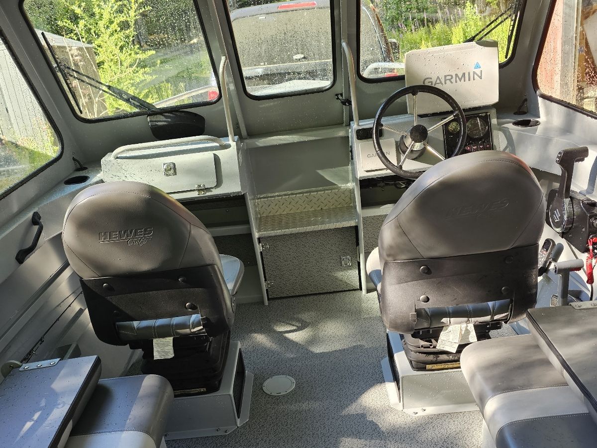 Interior of a Hewescraft Sea Pro 200 boat with two seats and a helm station.