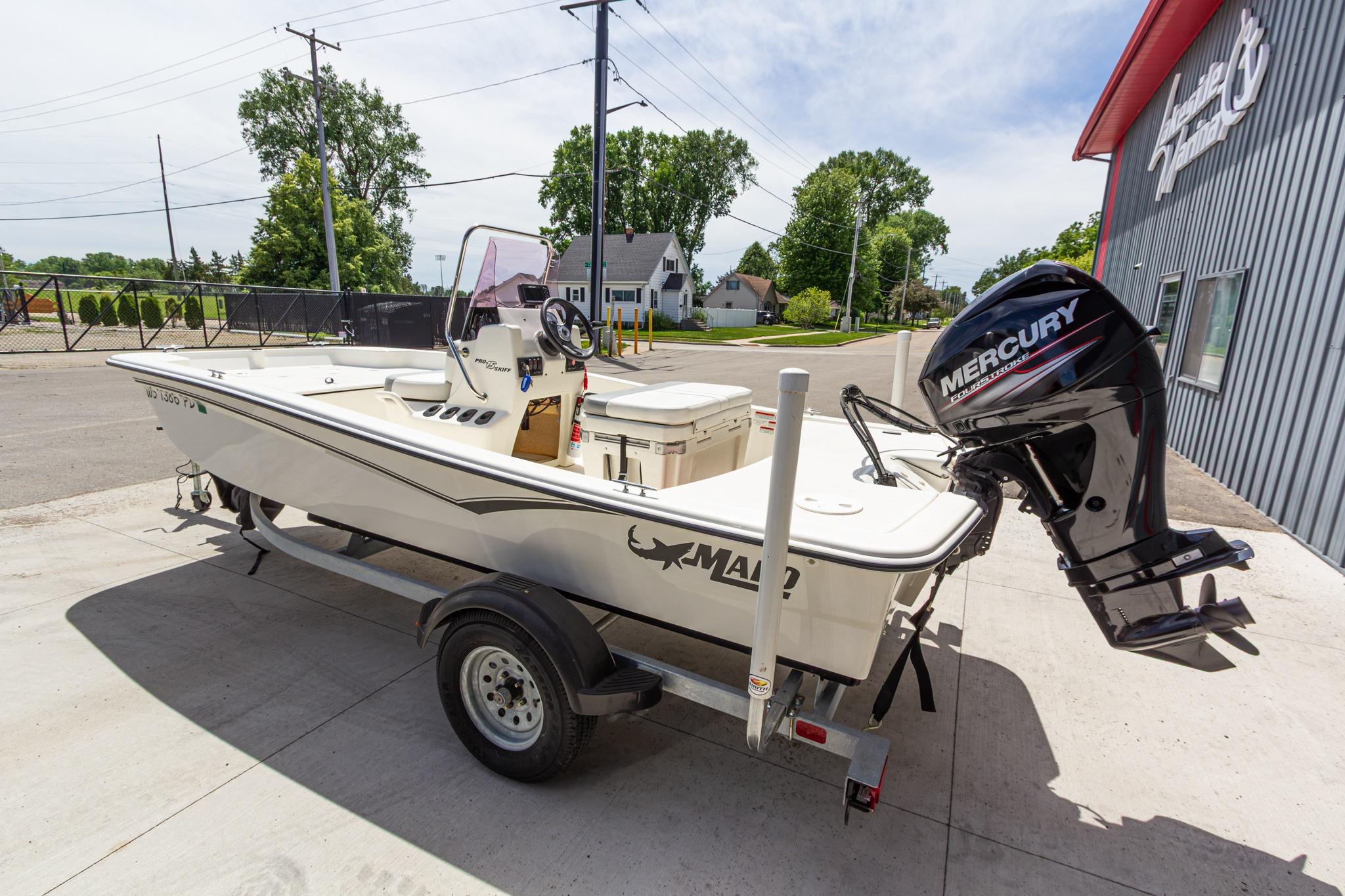2020 Mako Pro Skiff 15 CC boat with Mercury engine on trailer, parked outdoors.
