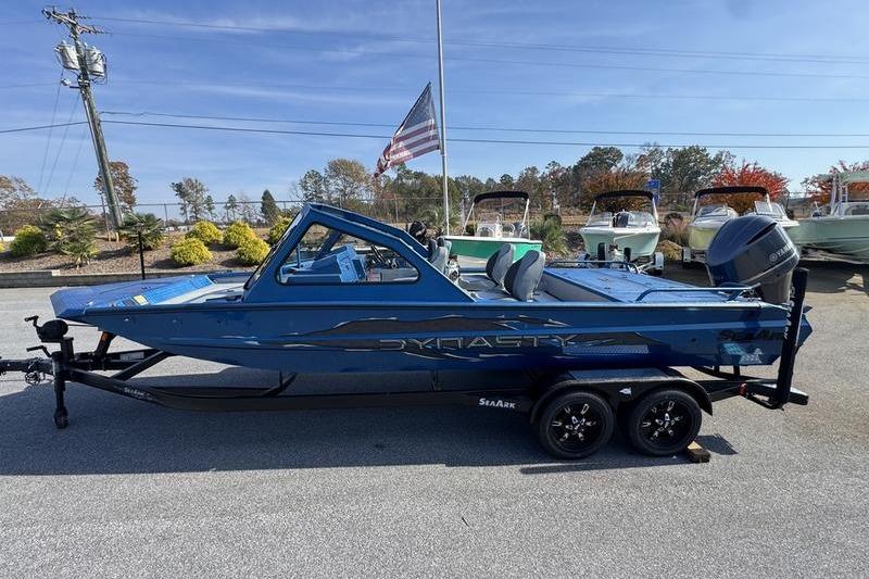 2026 SeaArk Dynasty 2.0 boat on trailer, blue color, parked outdoors.