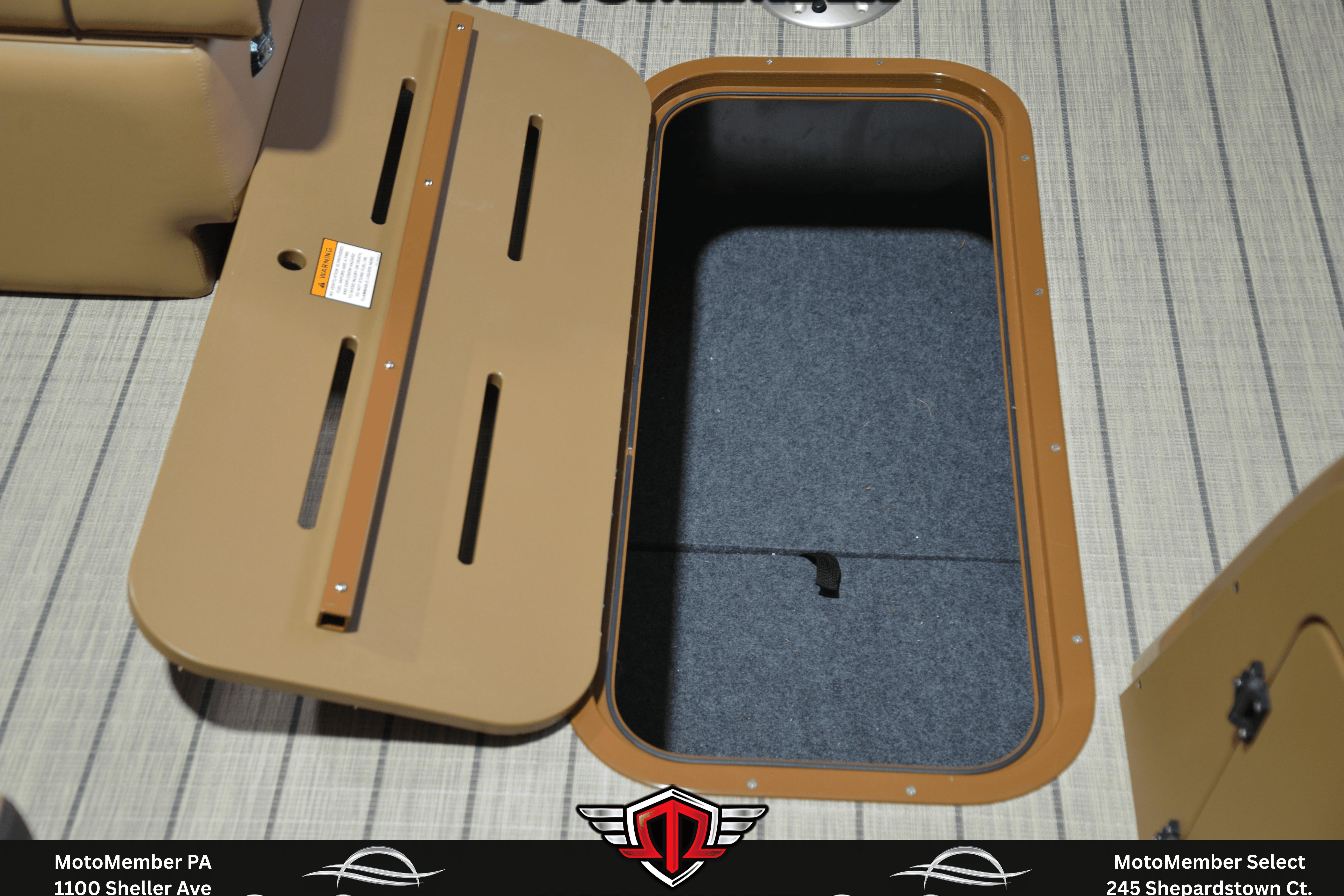 Open storage compartment on 2025 SunCatcher Fusion 324SS boat, featuring tan and gray interior.
