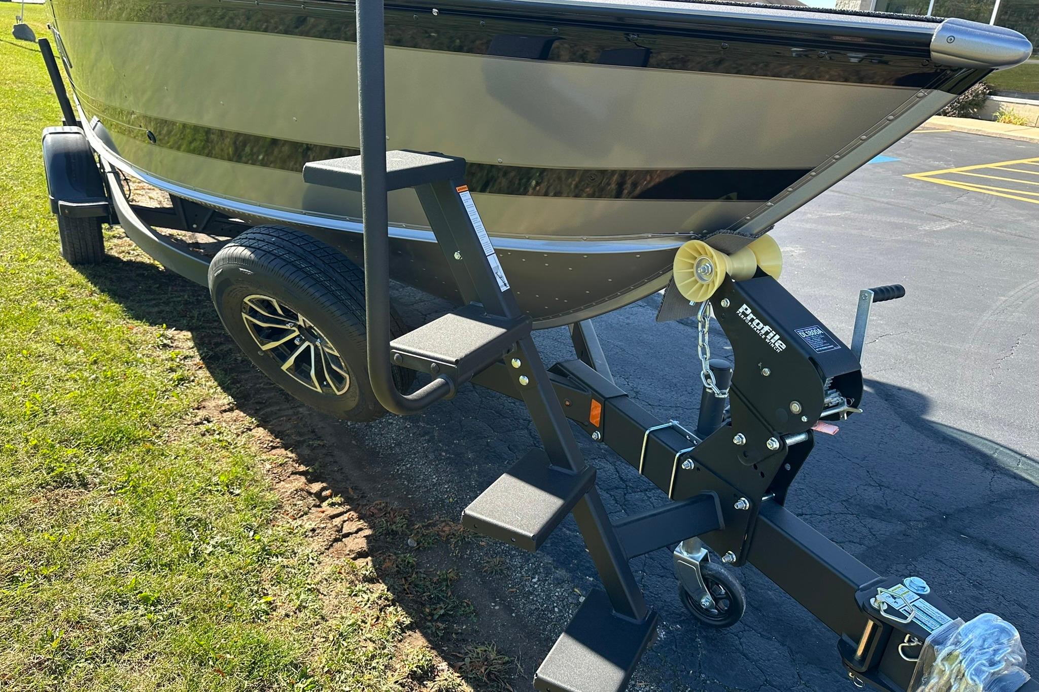 2026 Lund 1875 Impact XS Sport boat on trailer with step ladder and winch.