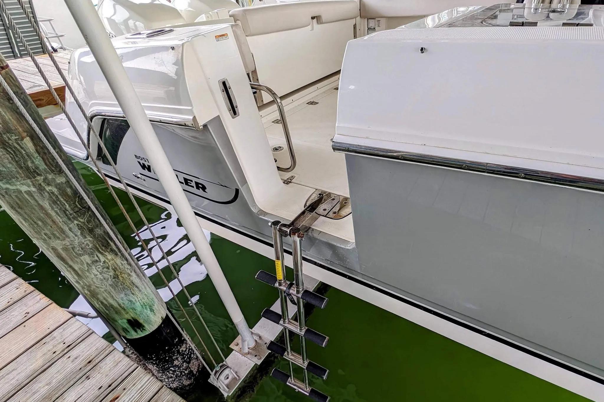 2017 Boston Whaler 320 Vantage boat docked with swim ladder and seating area visible.