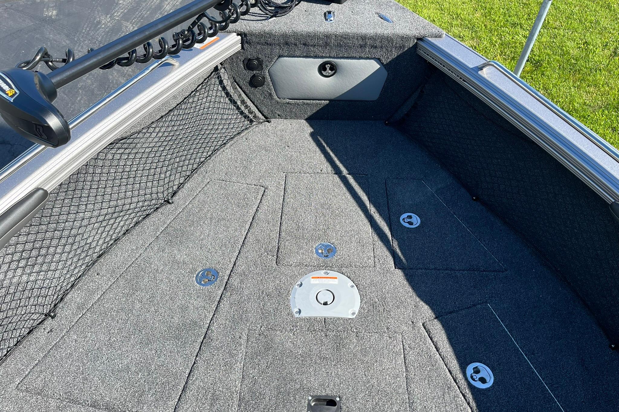 2026 Lund 2275 Baron boat interior with carpeted deck and storage compartments.