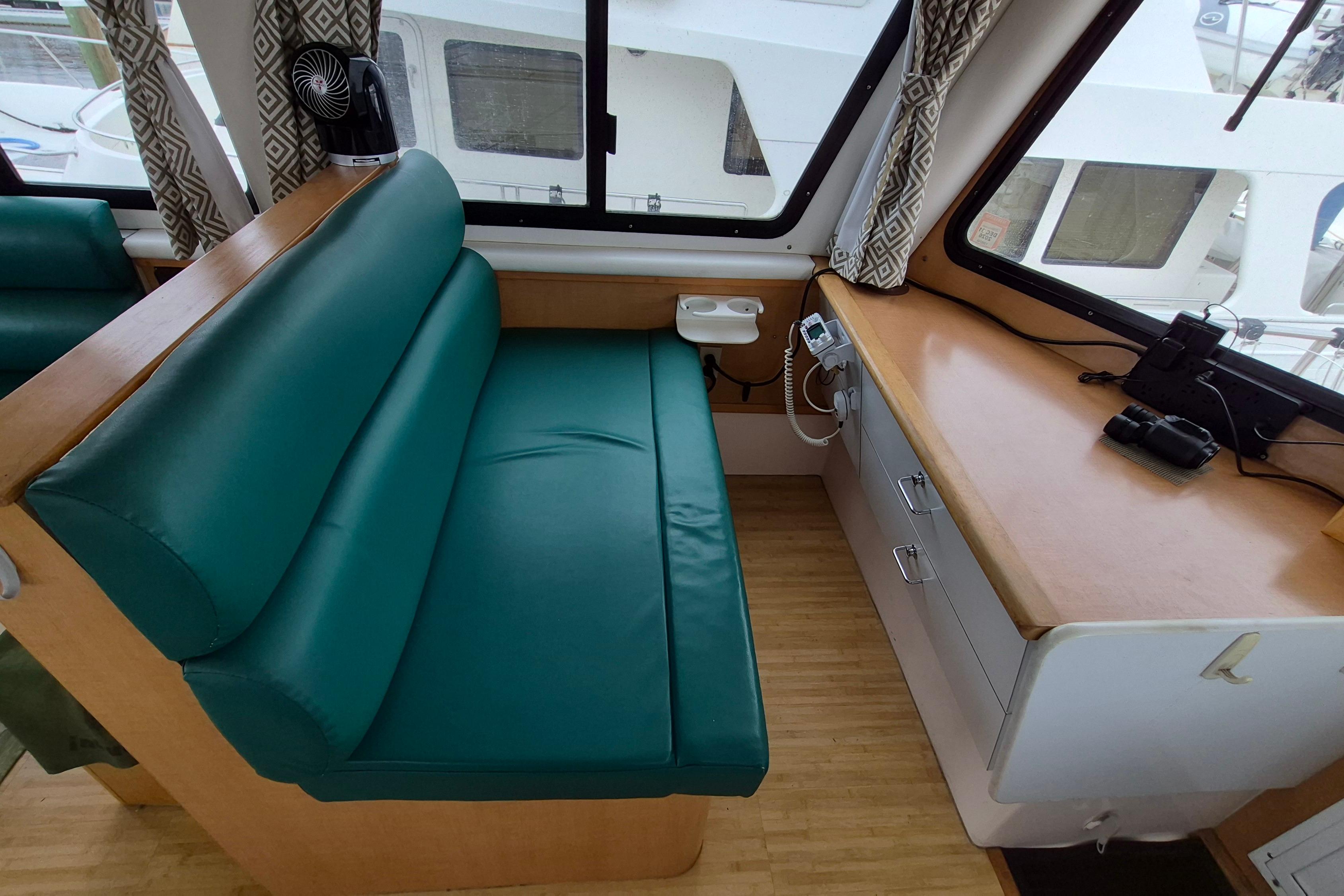 Interior of 2009 Endeavour 40 Skylounge with green seating and wooden desk.