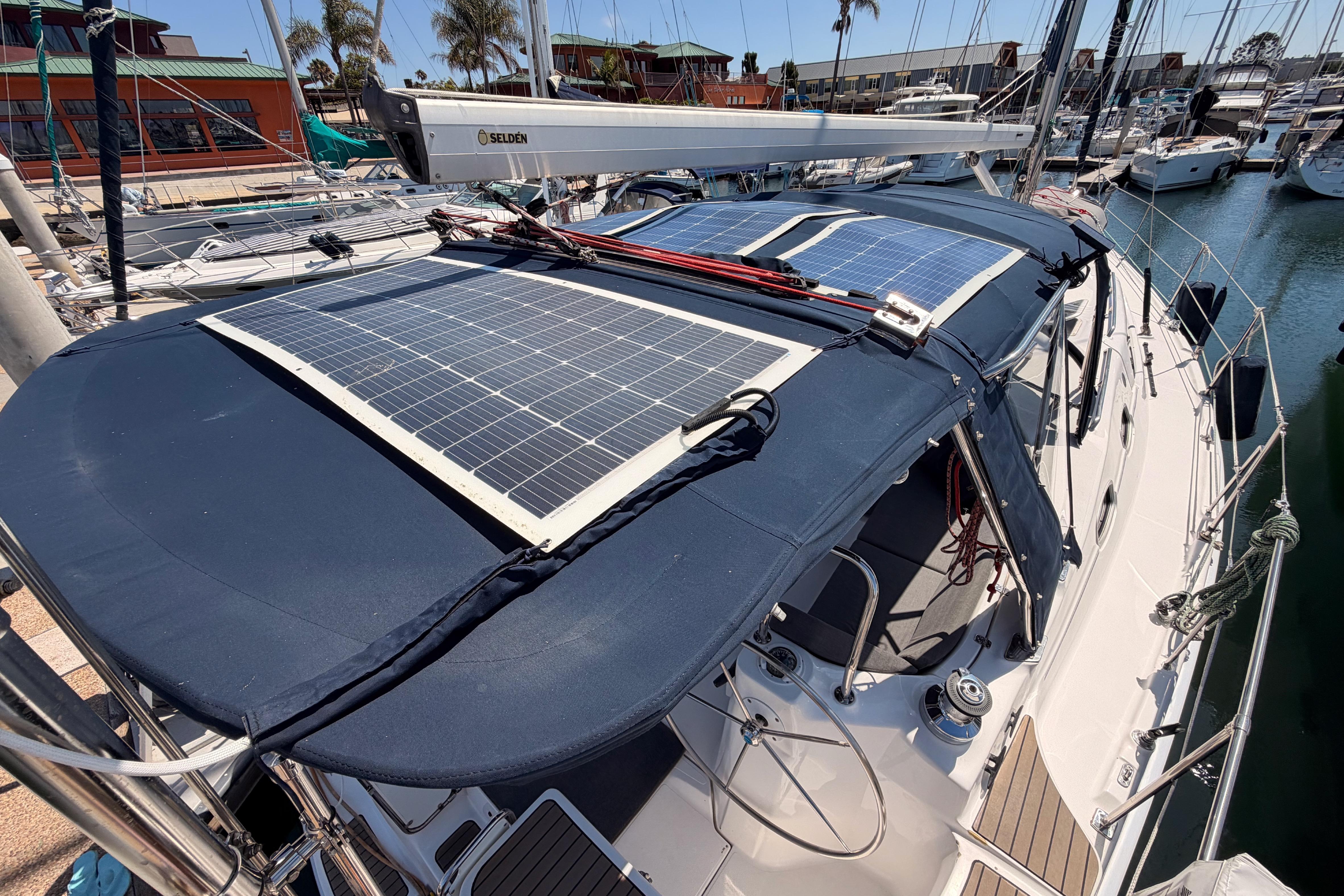 2008 Hunter 45 Deck Salon sailboat with solar panels docked at a marina.