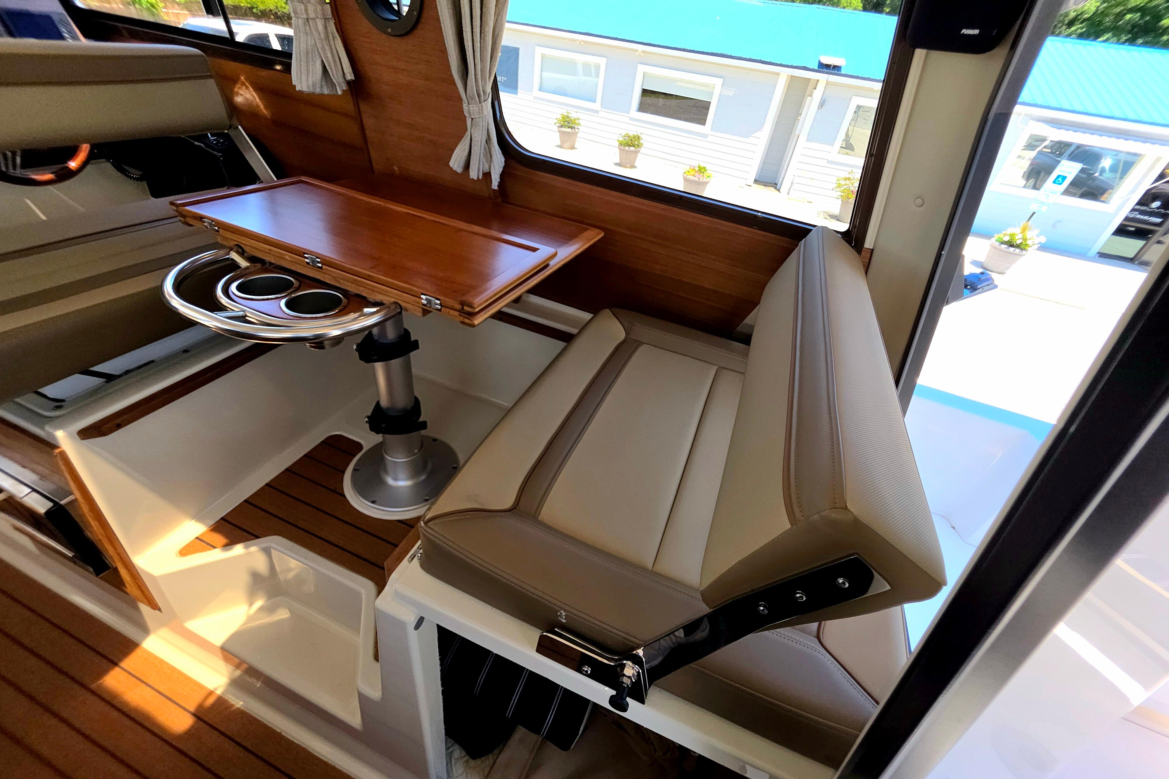 Interior of 2021 Ranger Tug R27 with seating and wooden table.