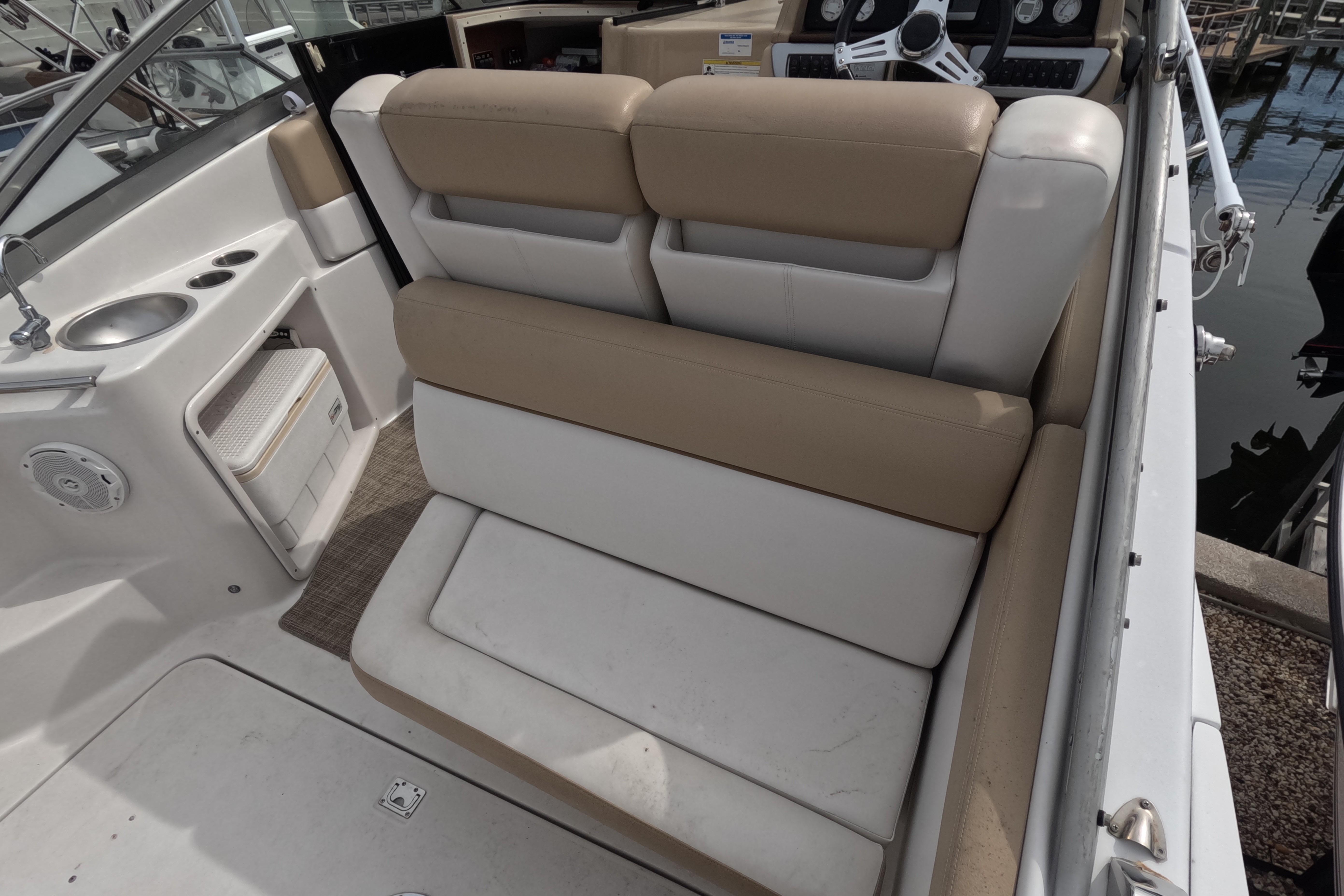2012 Four Winns V265 boat interior with beige seating and compact kitchenette.