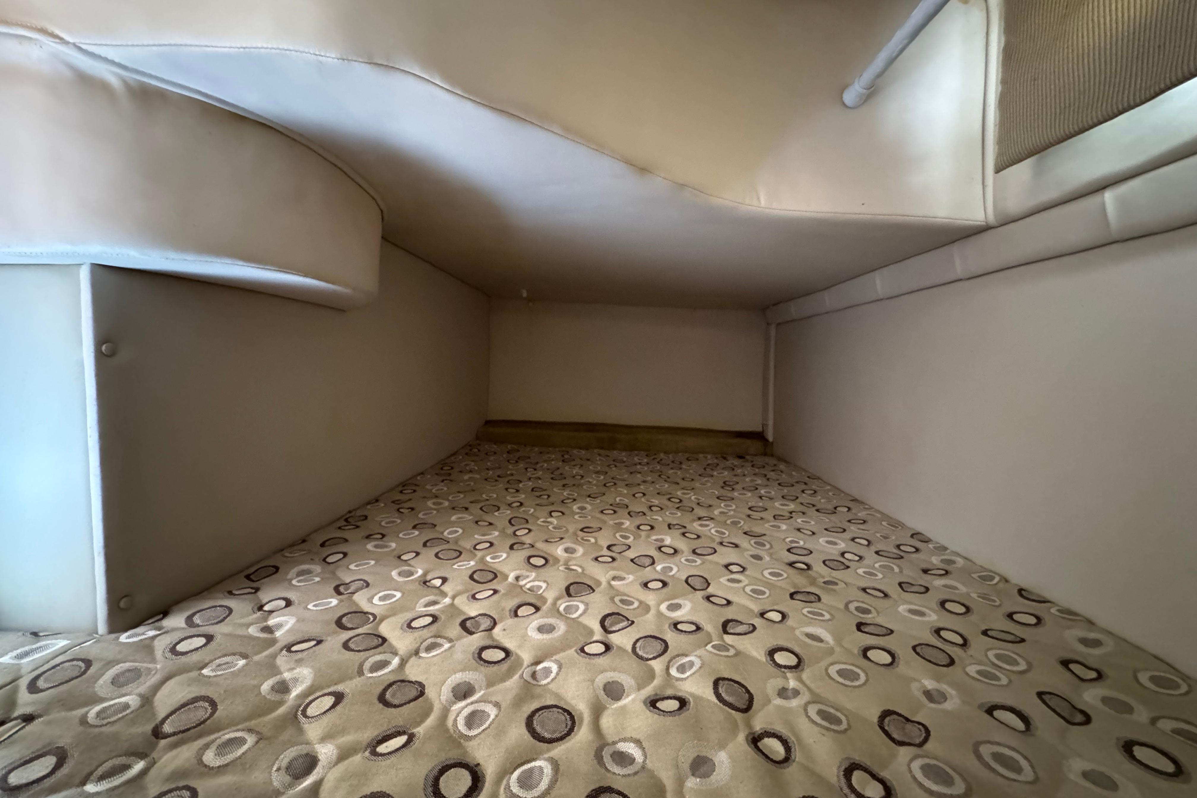 Interior cabin of 2008 Larson Cabrio 260 boat with patterned bedding.