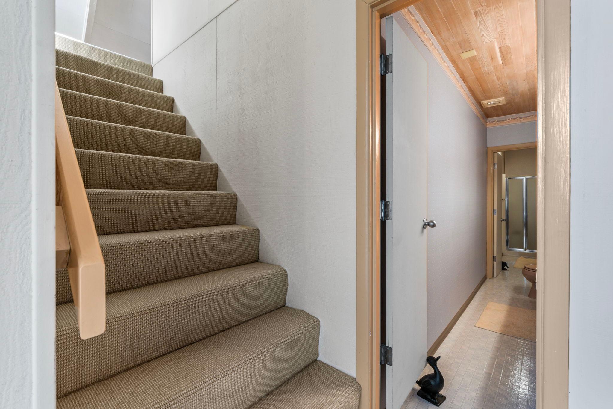 Carpeted staircase and hallway in a 1976 custom boathouse interior.