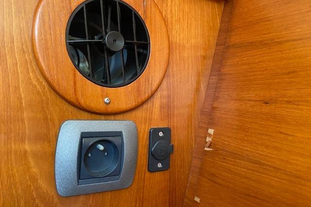 Wooden interior of 2008 Jeanneau Sun Odyssey 54 DS with vent and power outlet.