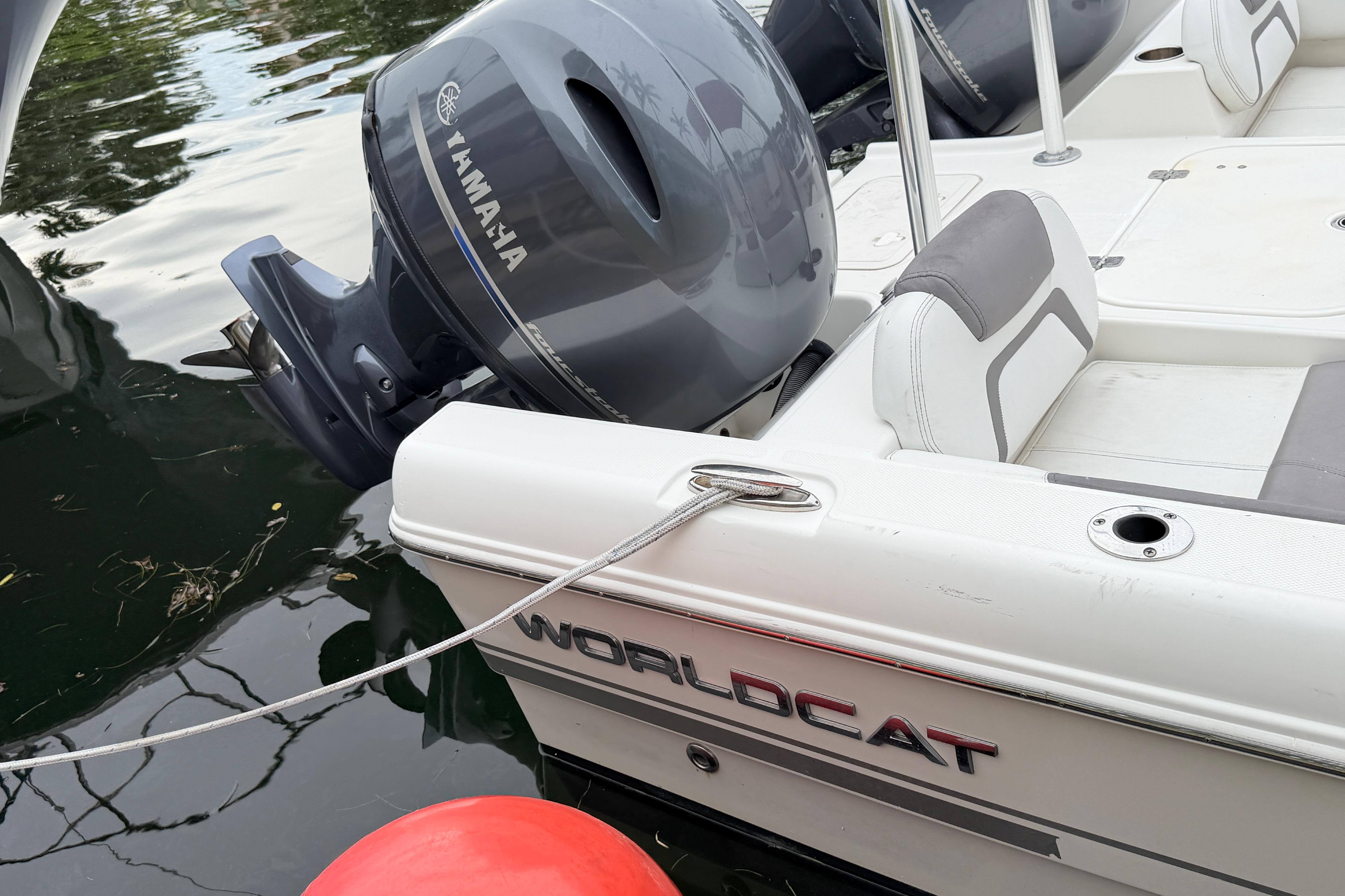 2019 World Cat 230 DC boat with Yamaha engine, docked on calm water.