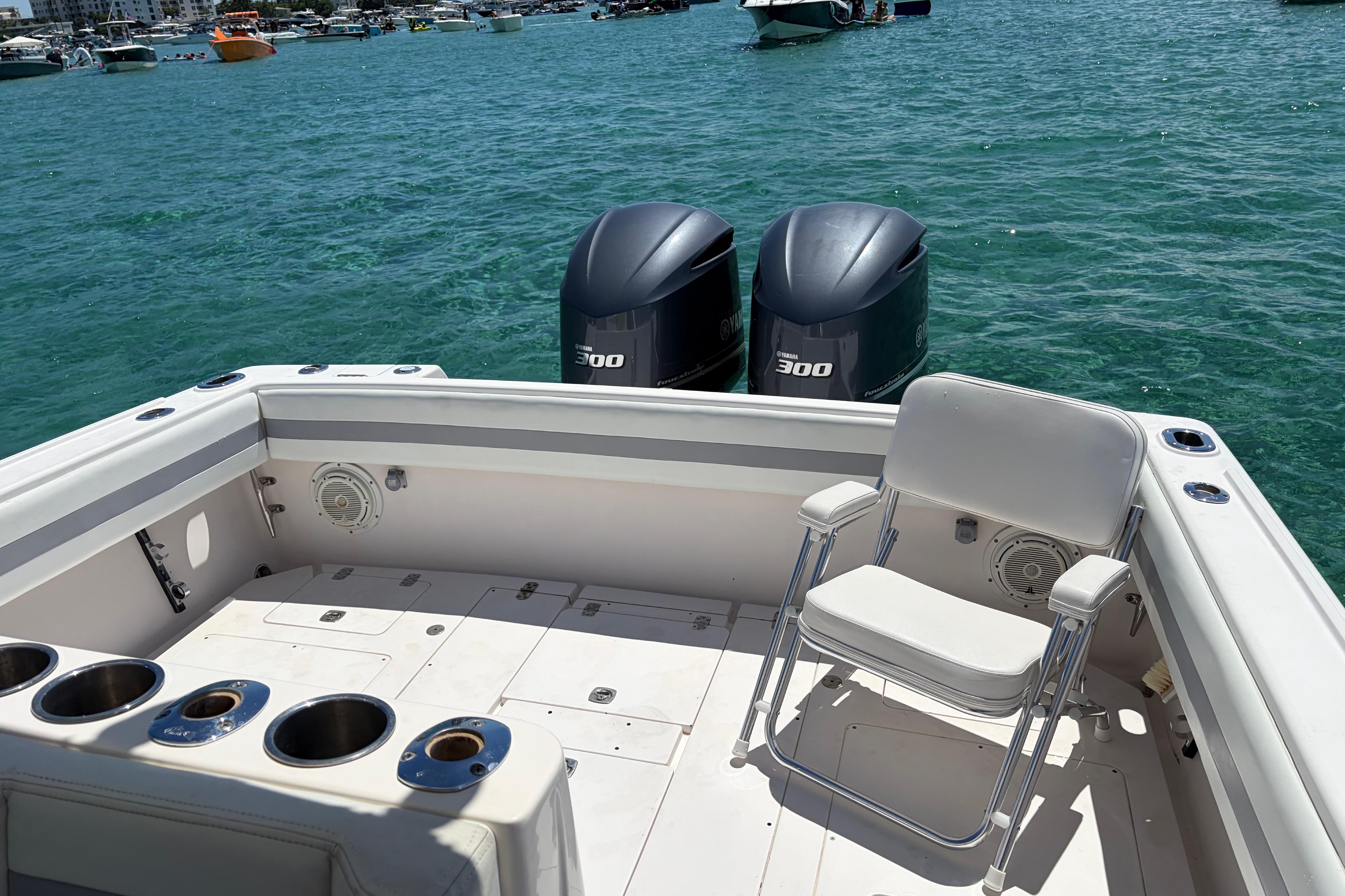 1998 Intrepid 339 Walkaround boat with twin 300 horsepower engines on clear water.