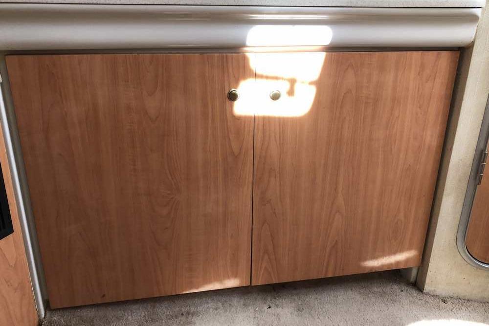 Wooden cabinet doors inside a 1999 Regal Commodore 2760 boat interior.