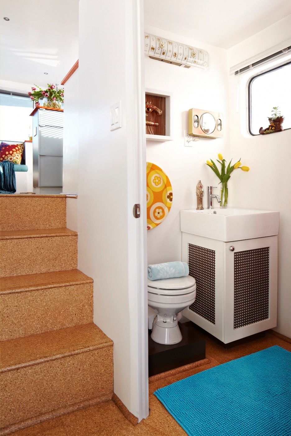 Interior of a houseboat with stairs, bathroom, and sink.
