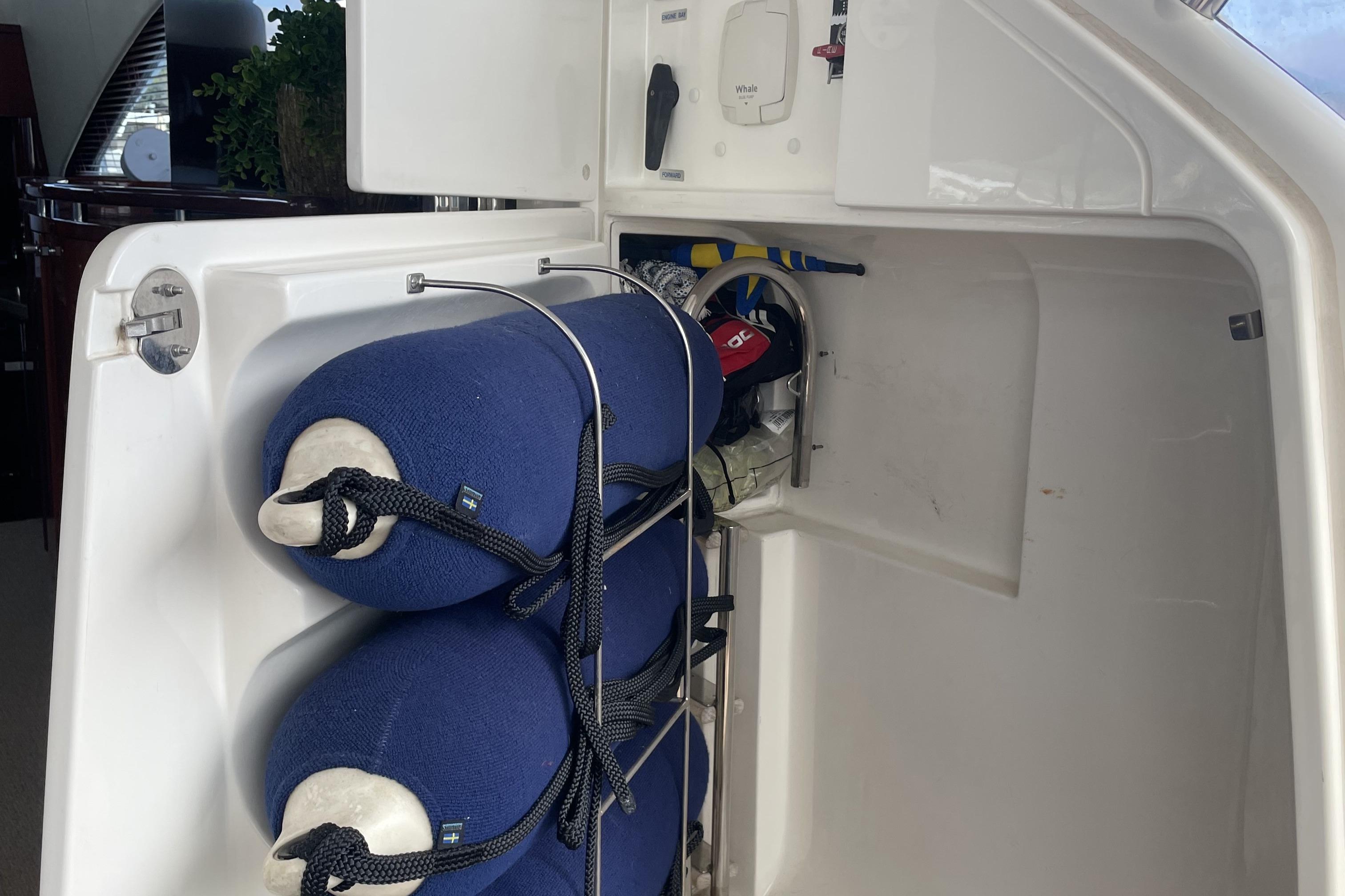 Storage compartment on a 2001 Fairline Squadron 58 yacht with blue fenders and equipment.