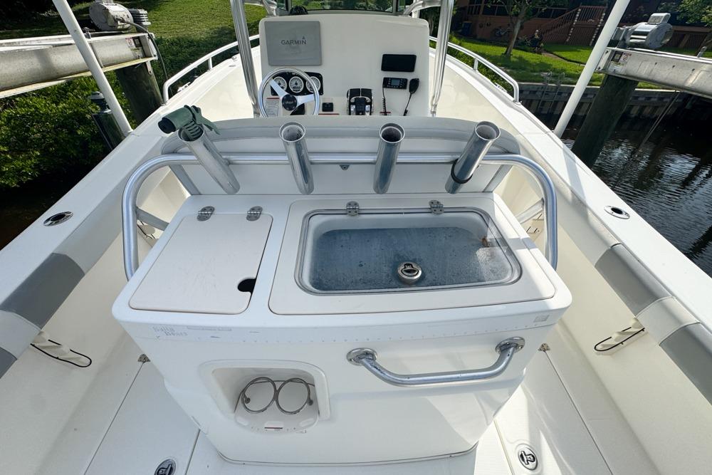 2018 Mako 284 Center Console boat with fishing rod holders and control panel.