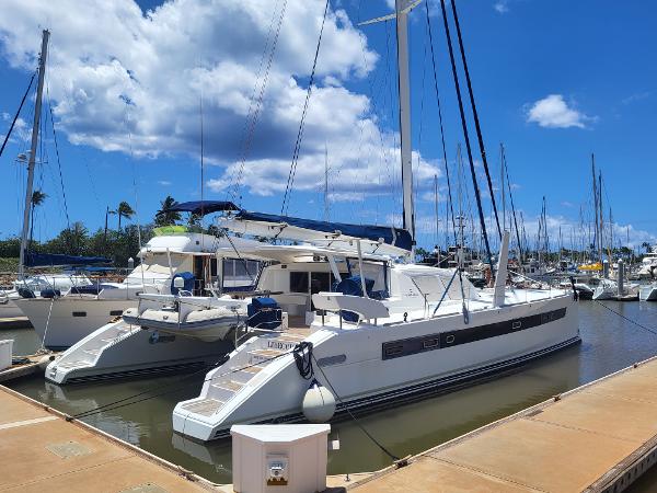 Catana 65 catamaran (2009) docked at a marina under a bright blue sky.