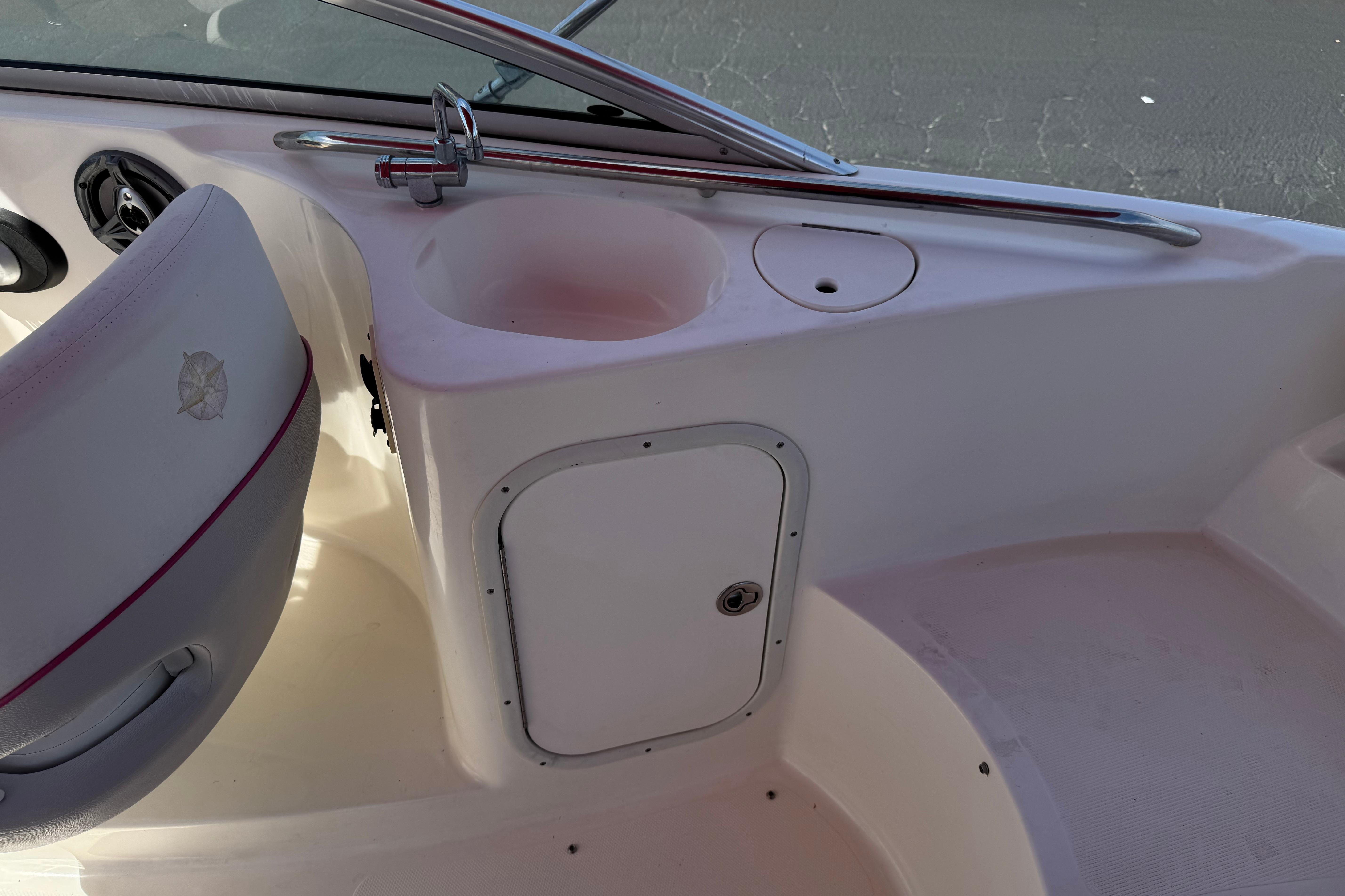 Interior of a 2010 Bryant 255 boat showing seating and storage compartment.