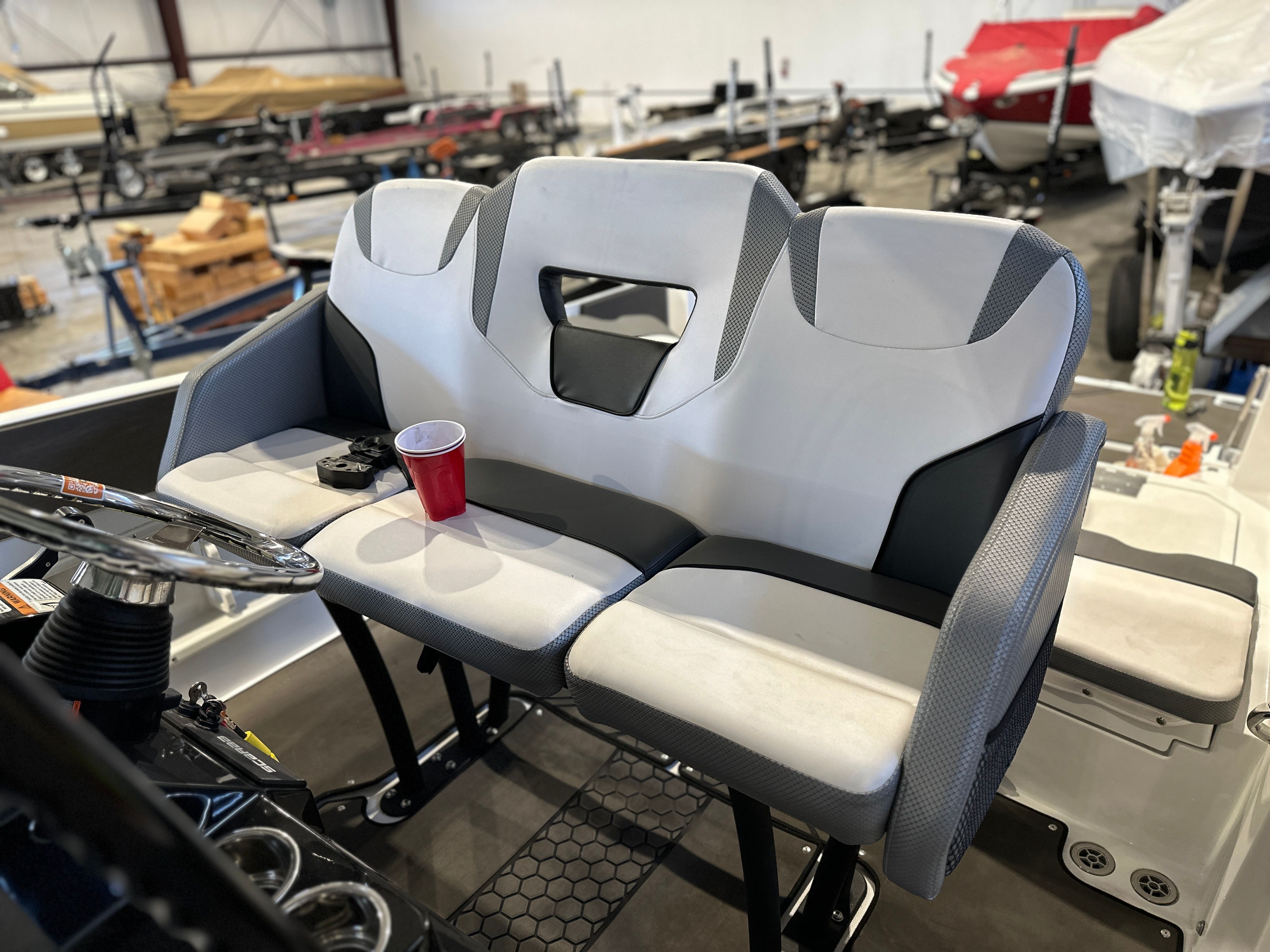 Interior view of a 2021 Scarab 255 Open ID showing a cushioned bench seat with a red cup.