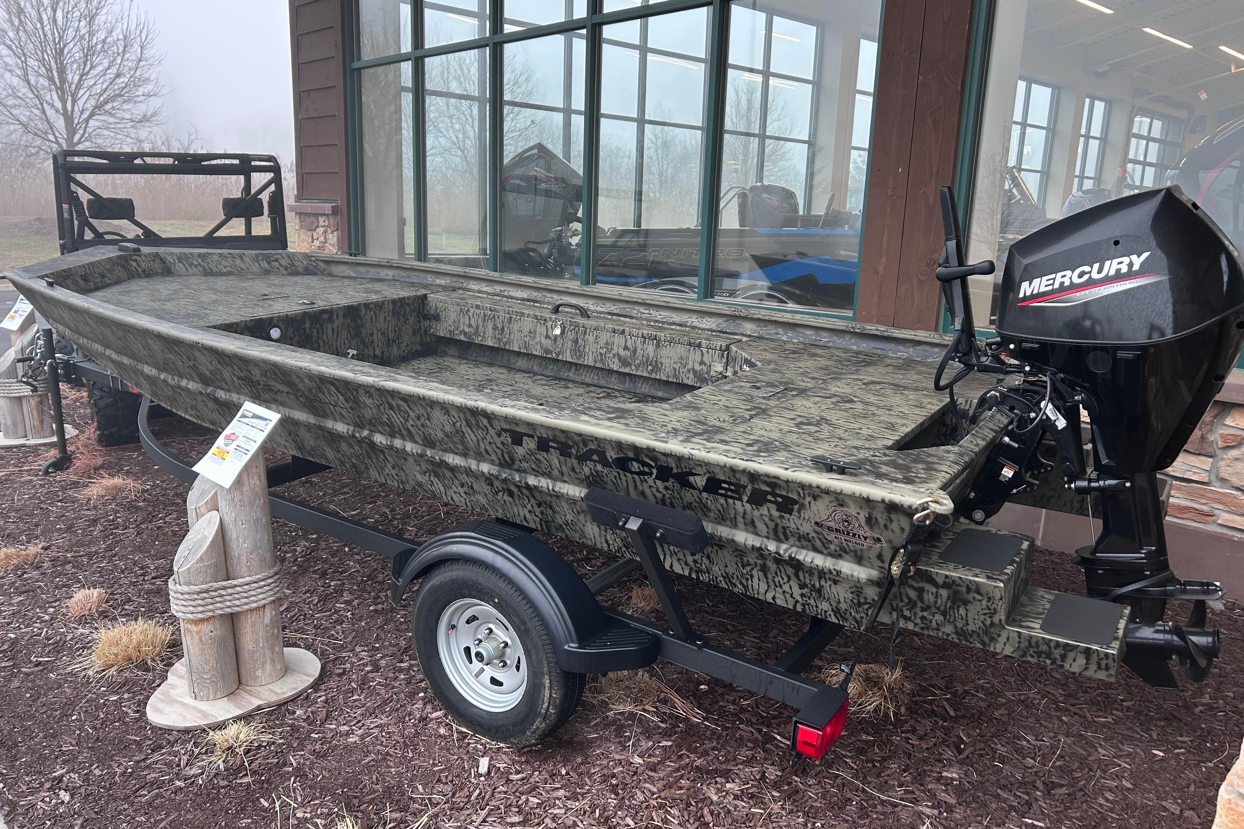 2026 Tracker Grizzly 1654 T Sportsman boat with Mercury engine on display.