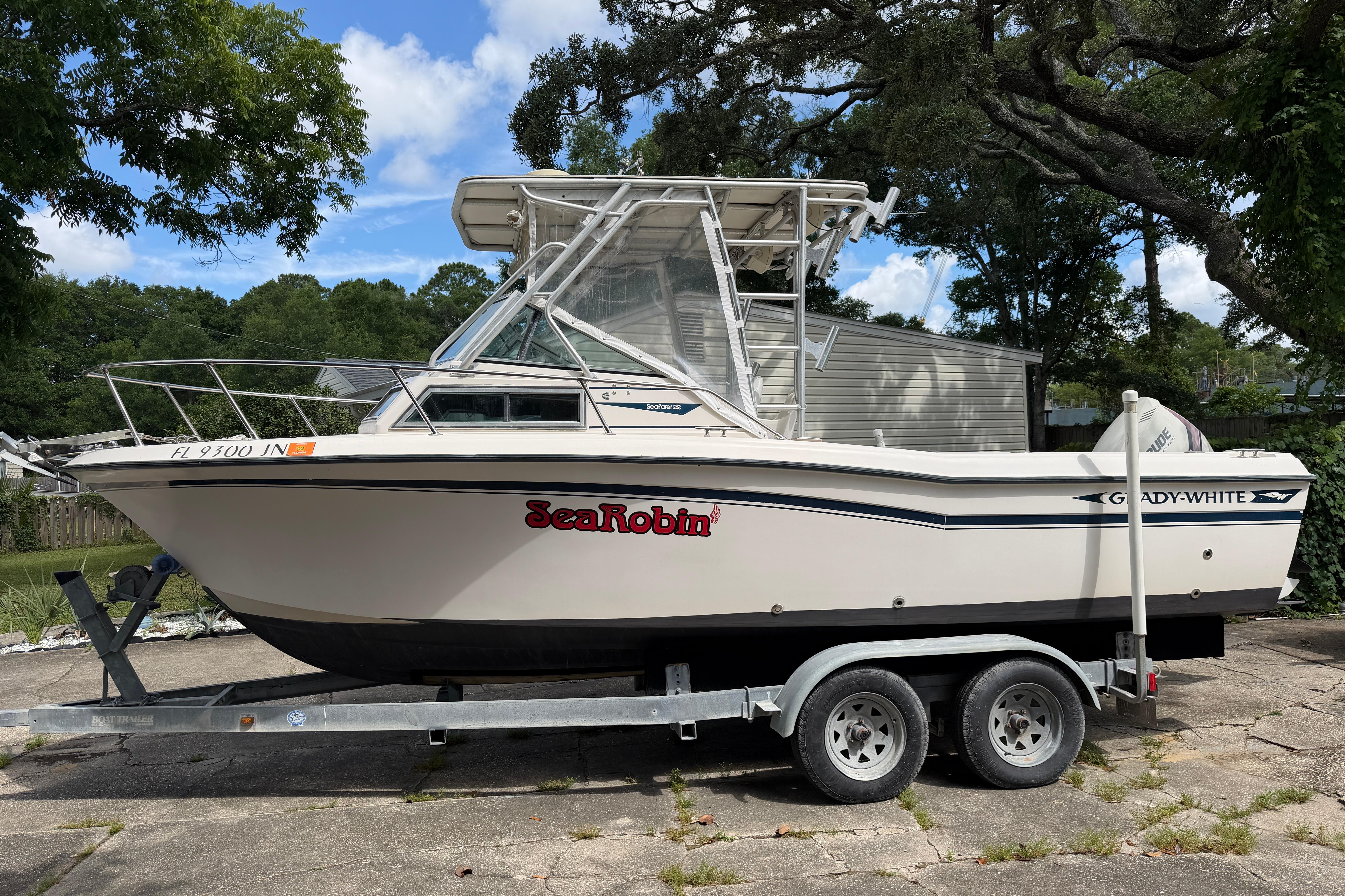 1987 Grady-White Seafarer 226 boat on trailer, parked outdoors under trees.