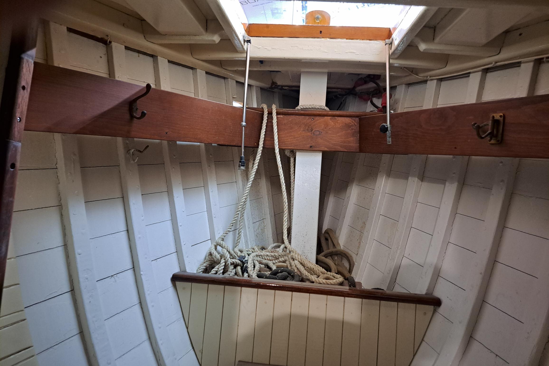 Interior of 1964 Stevens Seaspray 36 sailboat, featuring wooden beams and coiled ropes.