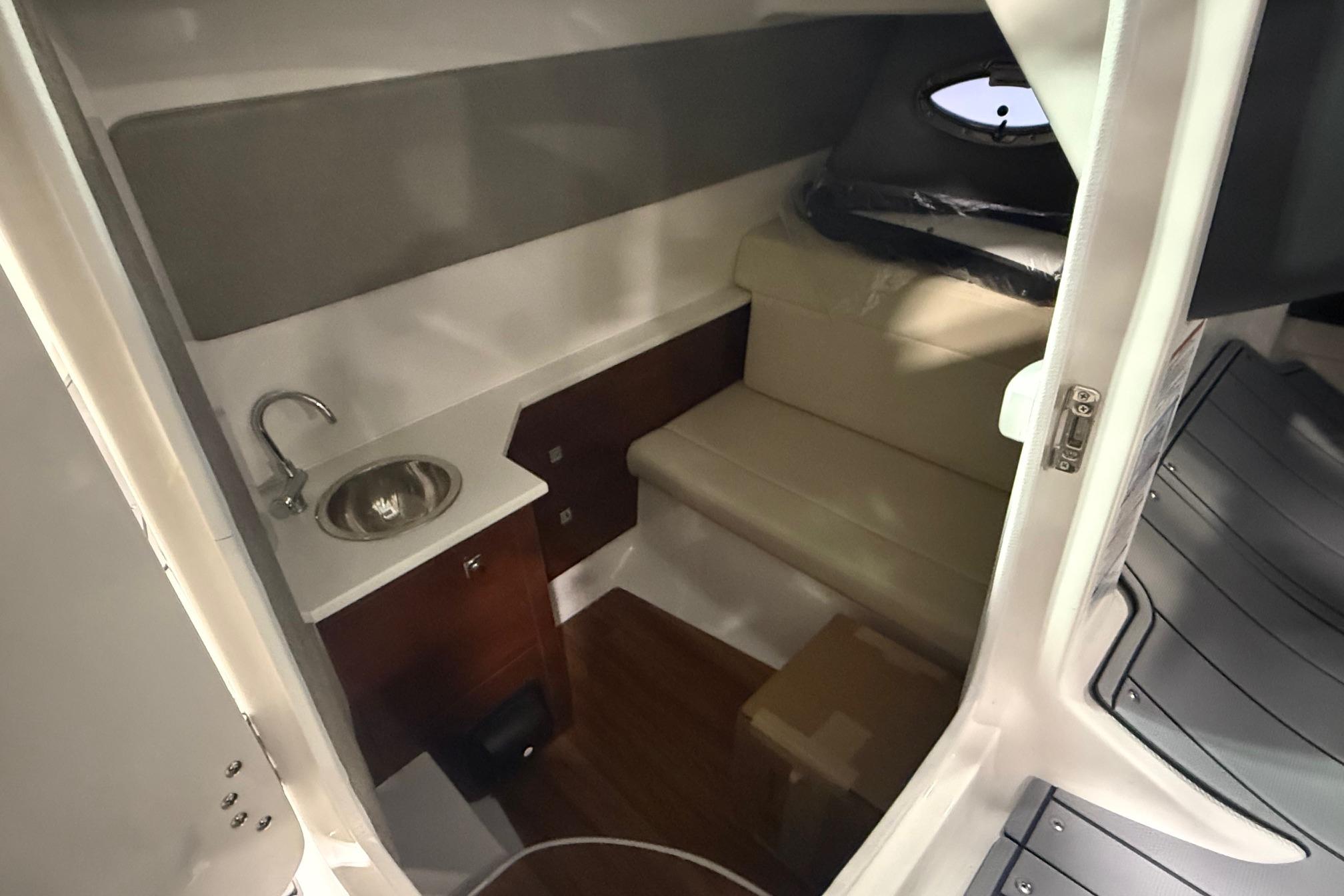 Interior cabin of 2026 Chaparral 280 OSX boat with sink and seating area.