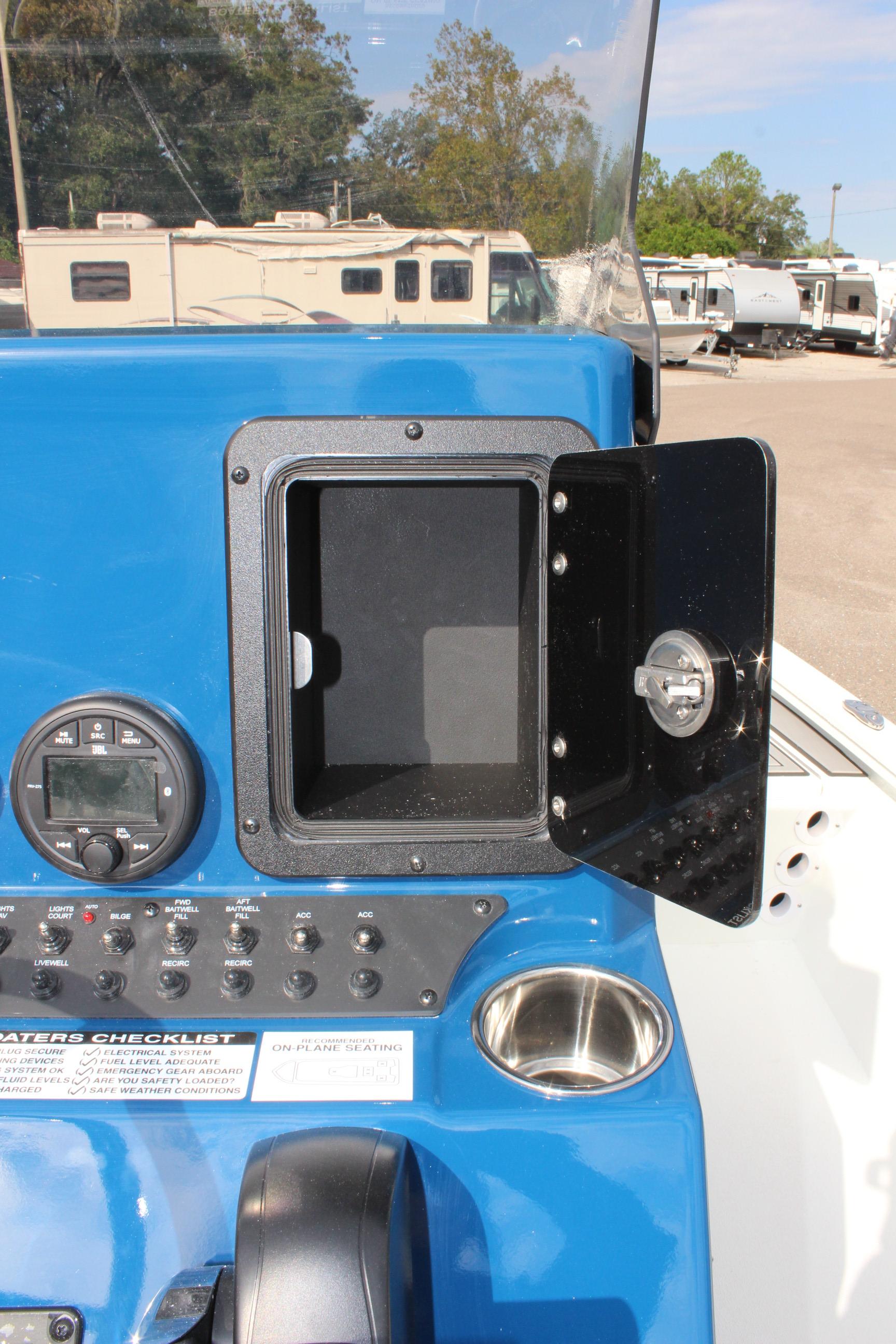 Avid 19 FSX 2025 boat dashboard with open storage compartment and control panel.