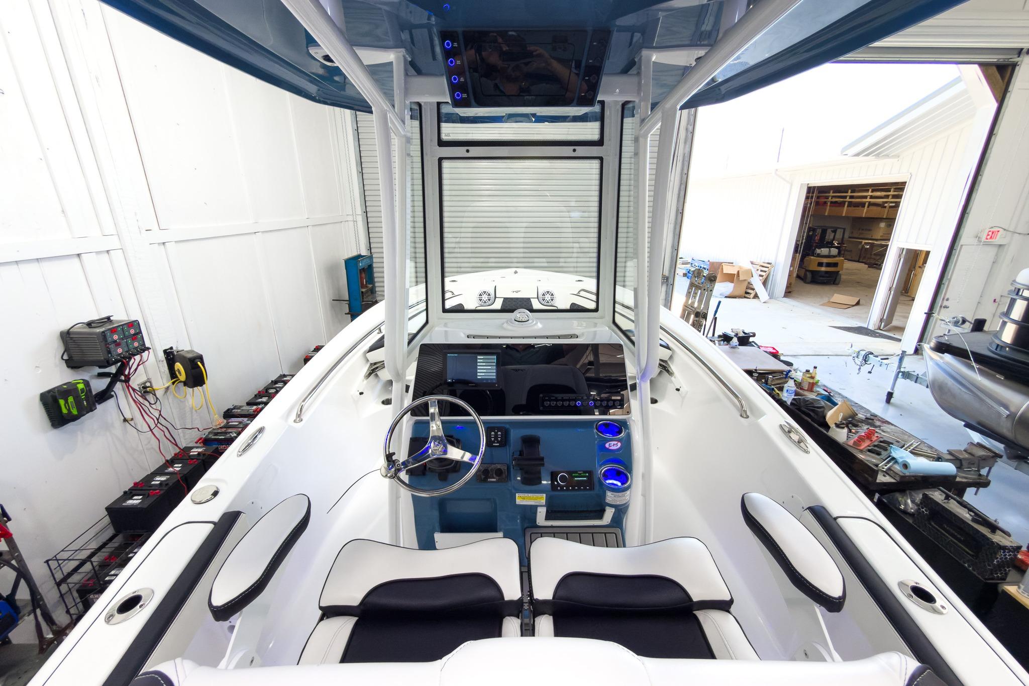 The image shows the cockpit of a Tidewater 220 LXF boat in a workshop.