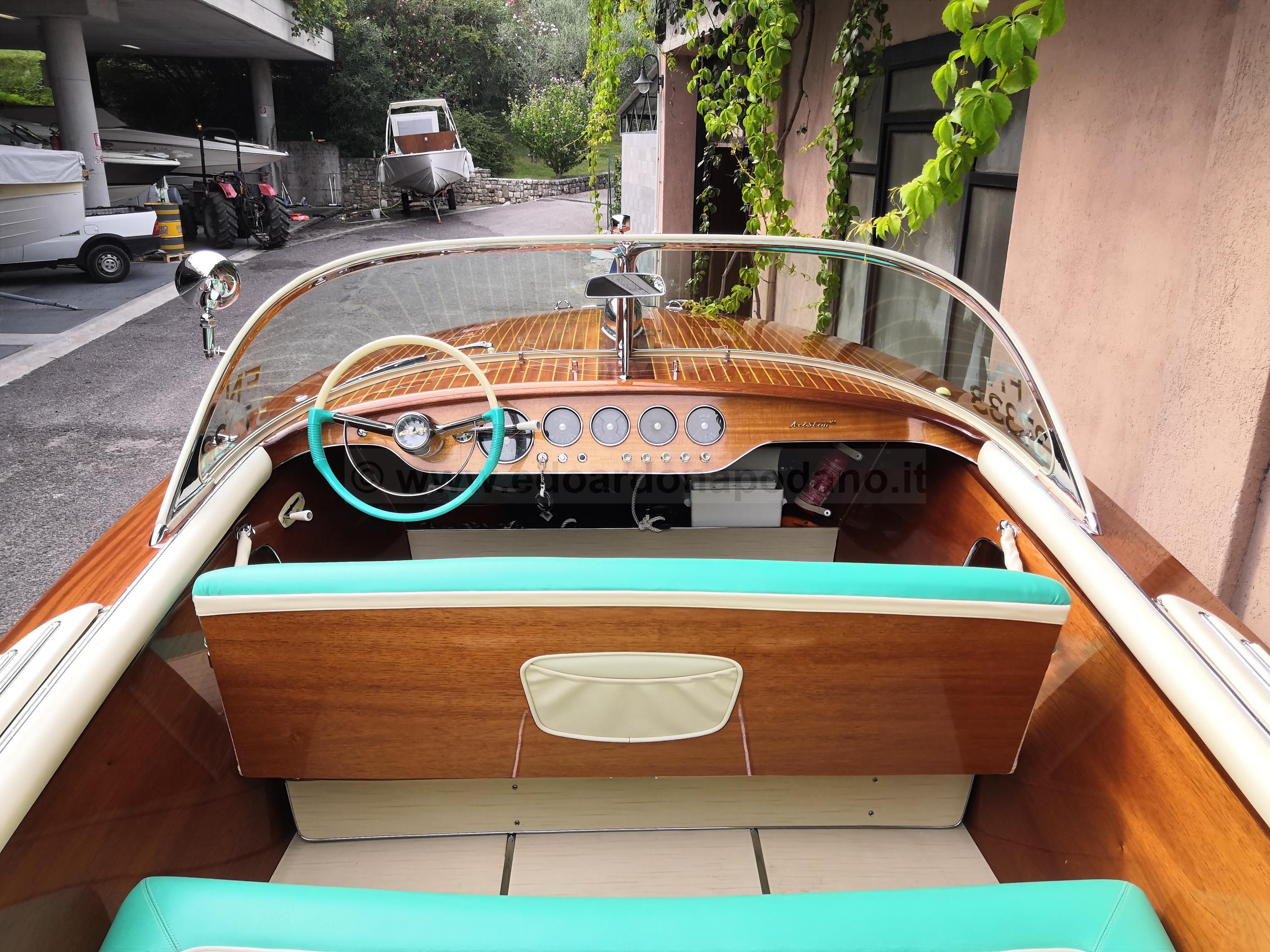 1963 Riva Ariston boat interior with wooden dashboard and turquoise seating.