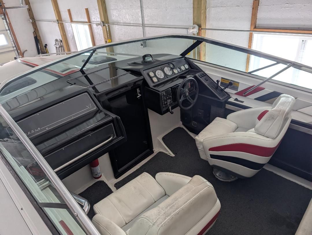 The image shows the cockpit of a 1989 Formula F223LS boat with two white seats and a black dashboard.