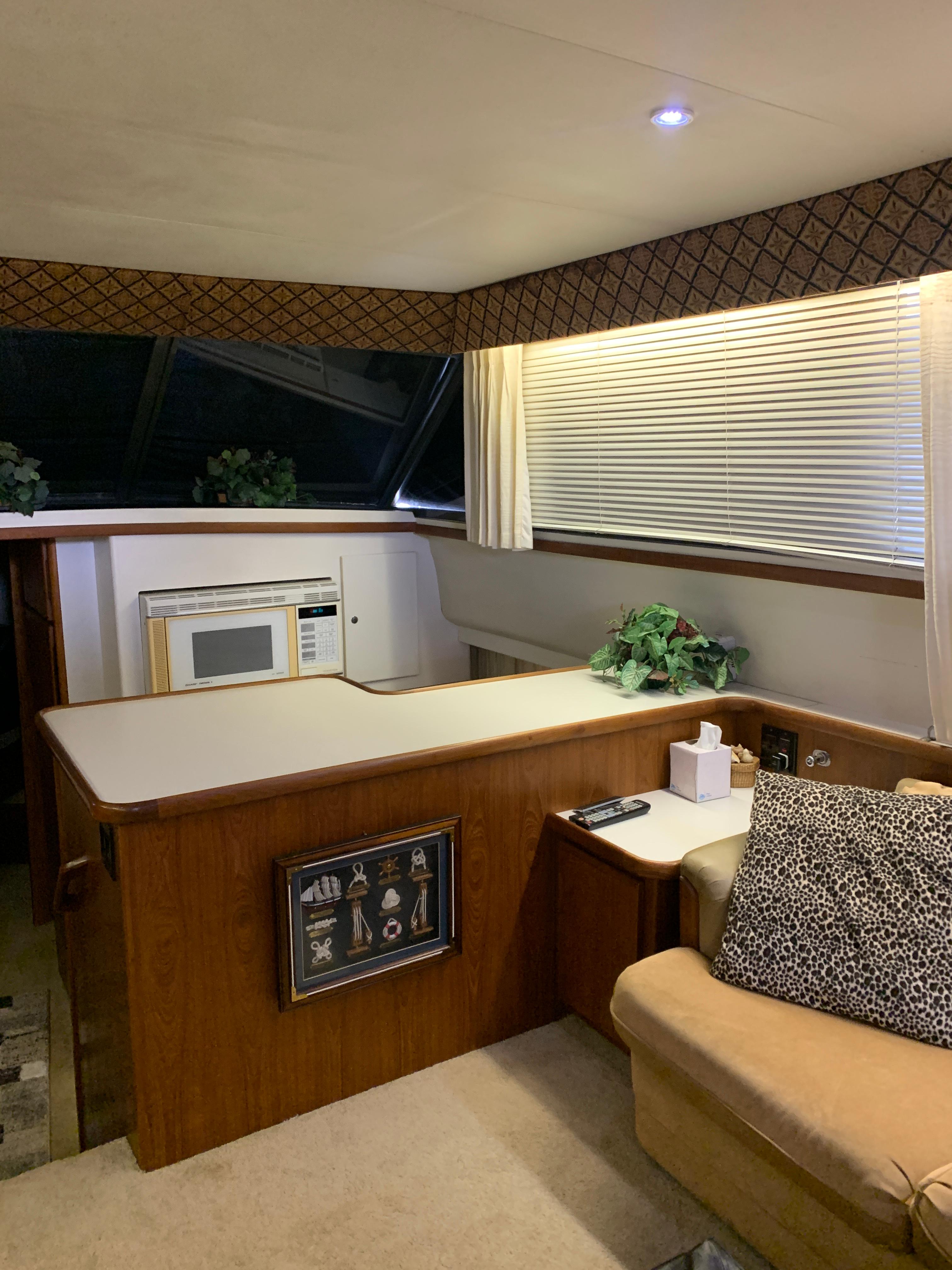 Interior of 1994 Carver 440 Aft Cabin Motor Yacht with cozy seating and kitchenette.