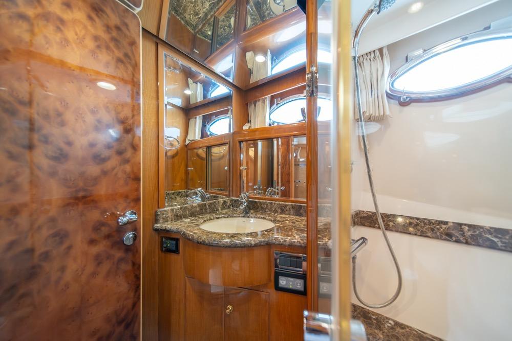 Luxurious bathroom in 2005 Ocean Alexander 64 Motoryacht with marble countertop and wood accents.