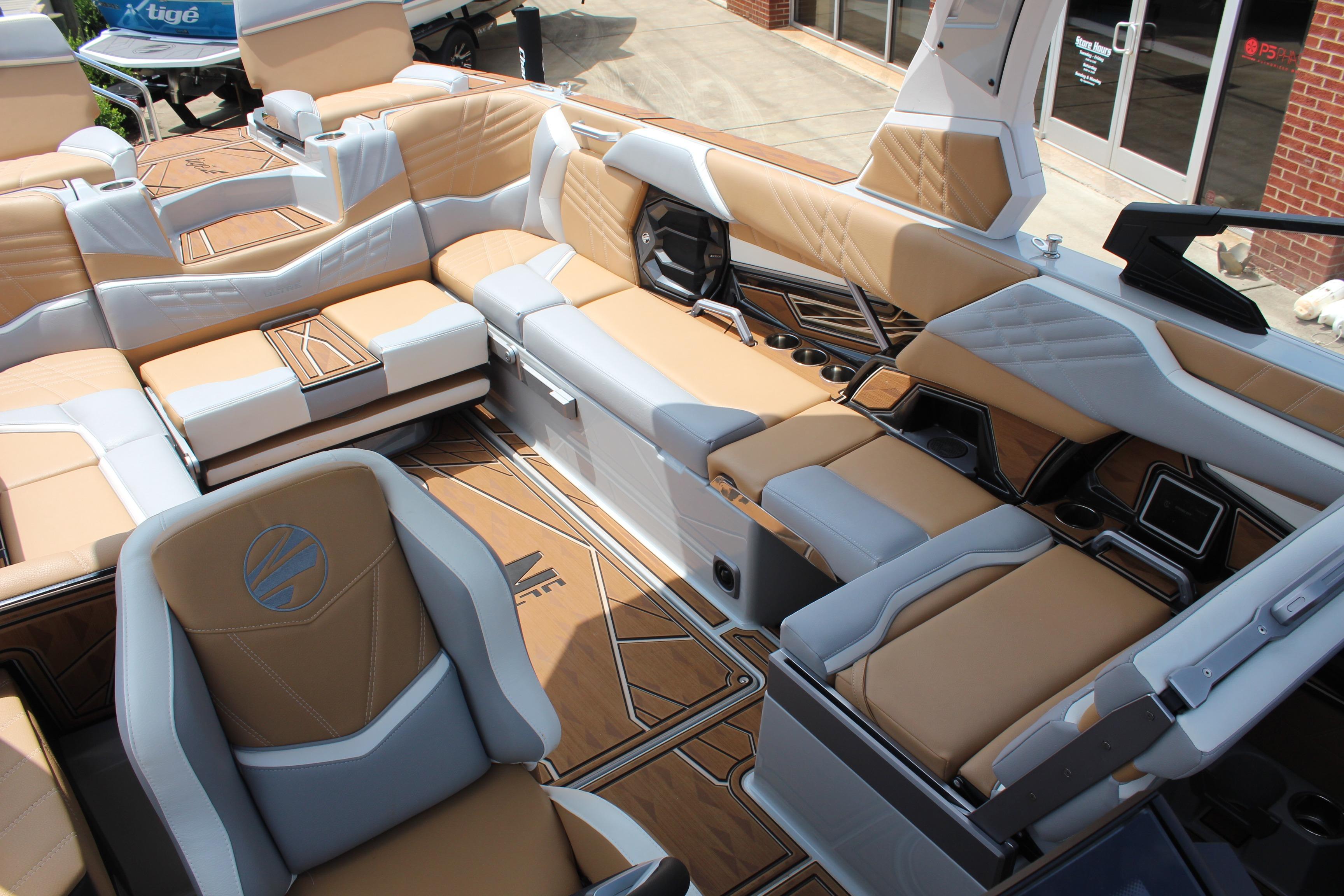 2024 Tigé Ultré 25ZX boat interior with luxurious tan and gray seating, cup holders, and modern design.