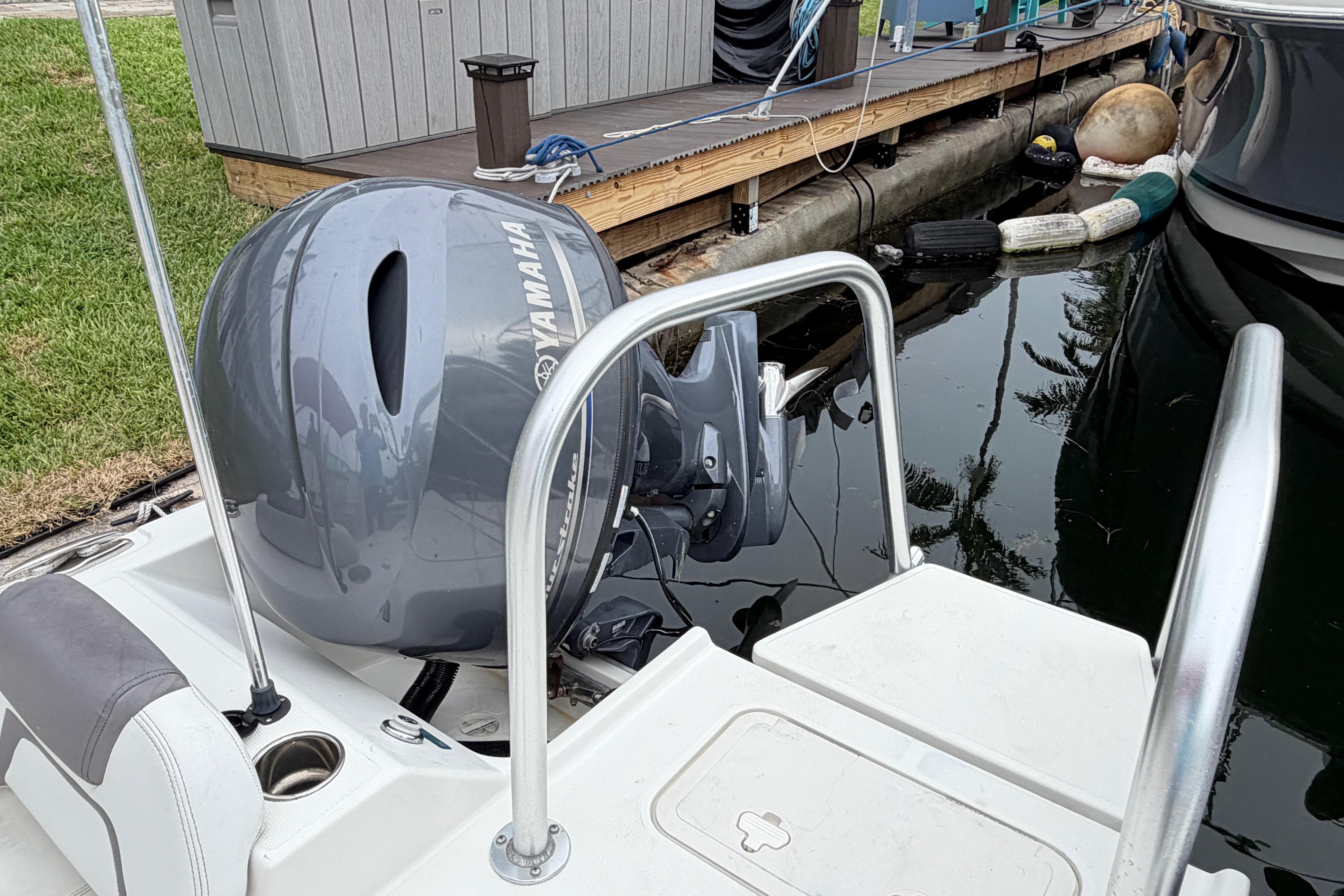 2019 World Cat 230 DC boat with Yamaha outboard motor docked by the water.