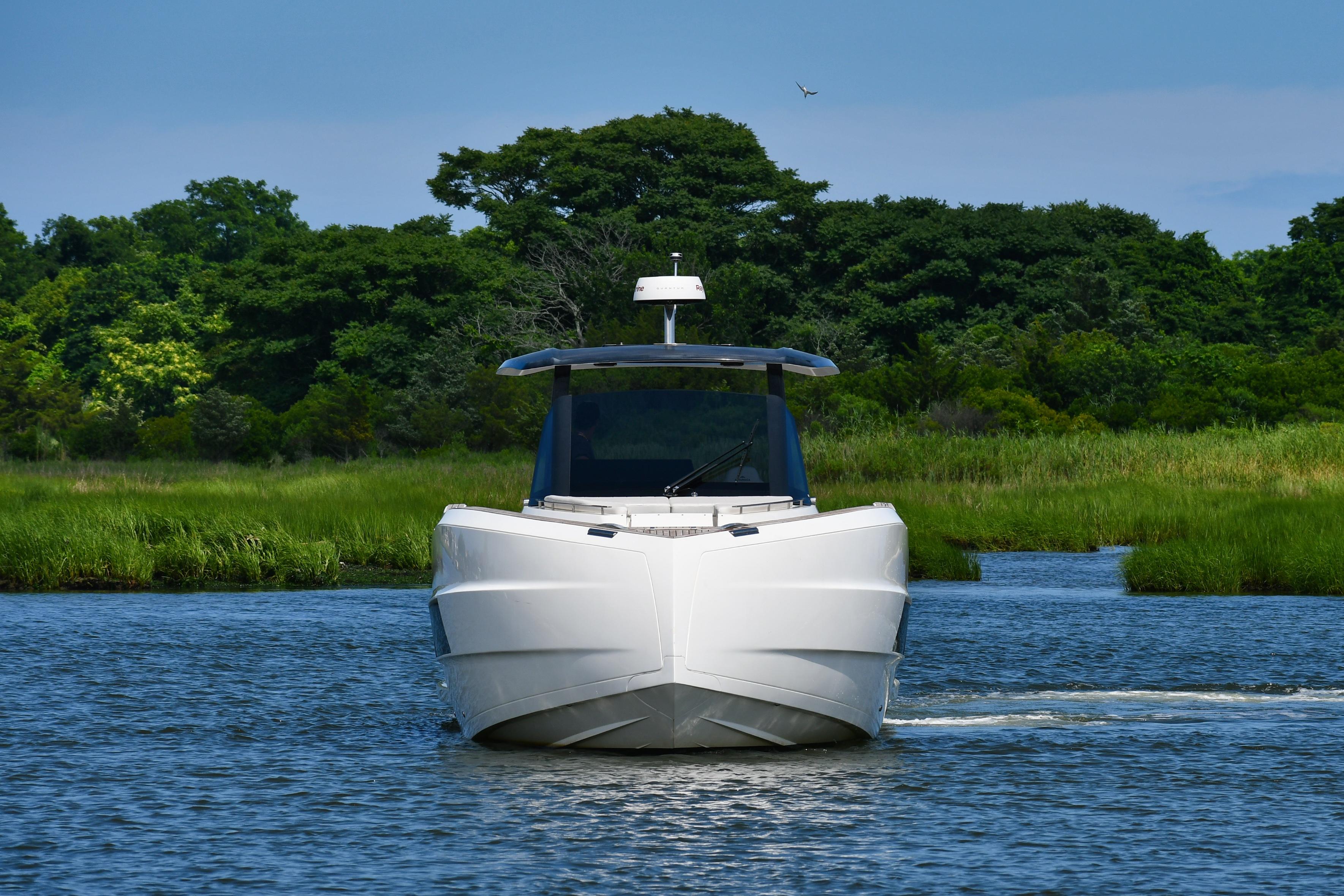 2023 Astondoa 377 Coupe Outboard cruising on a serene river with lush greenery.