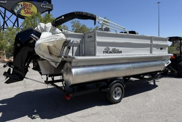 2026 Sun Tracker Party Barge 18 DLX pontoon boat on trailer, parked outdoors.