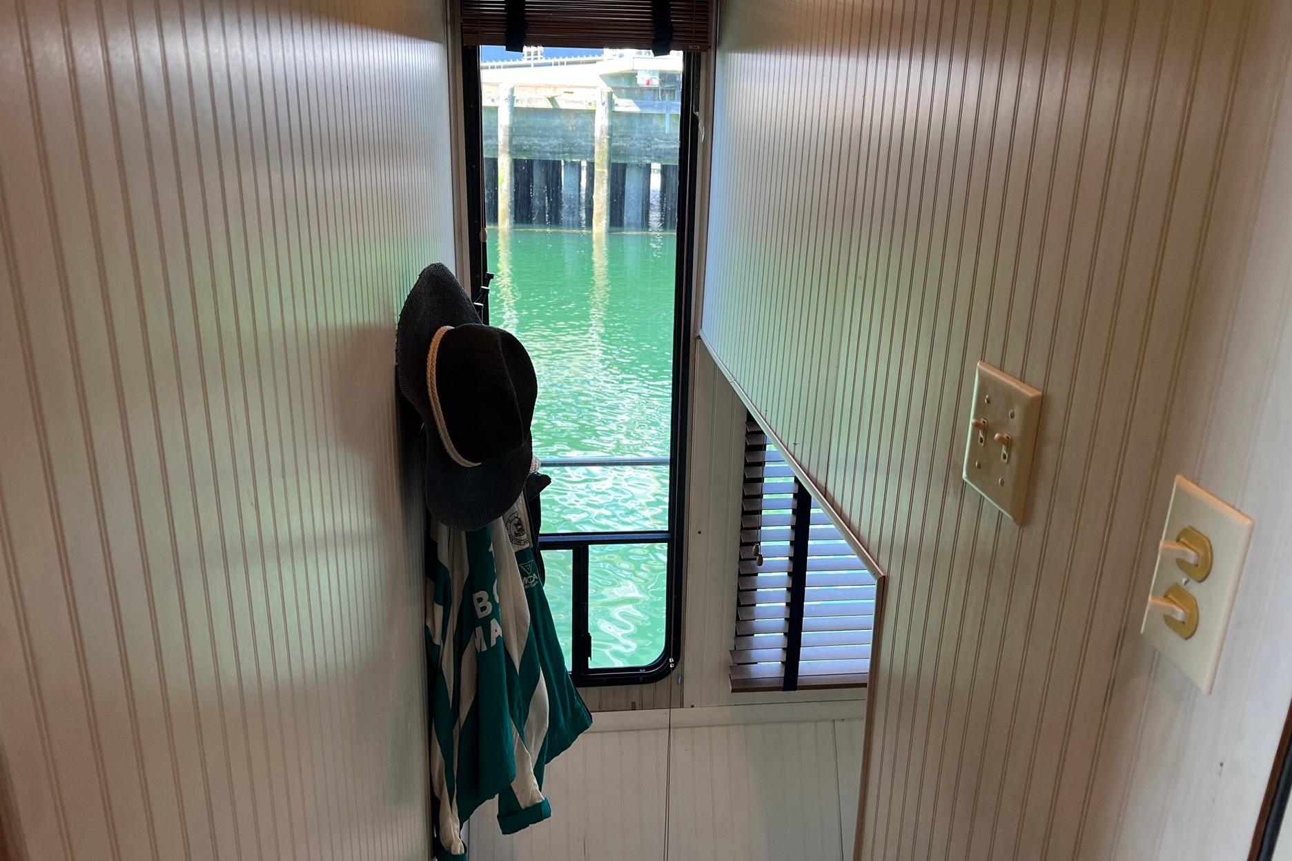Narrow hallway inside a 1993 Sumerset houseboat with a view of the water.