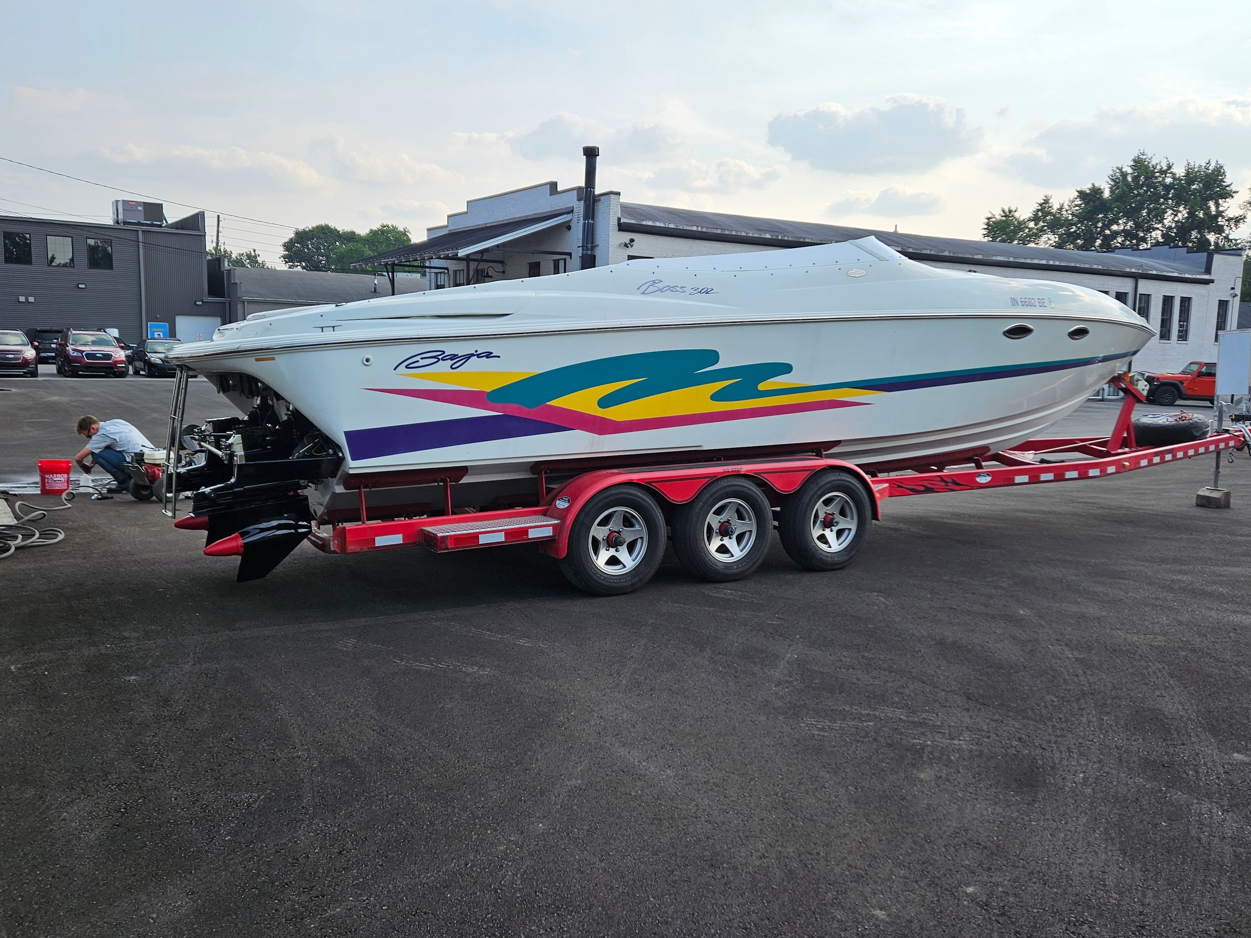 A 1996 Baja 302 Boss on a red trailer, featuring colorful stripes on the side.