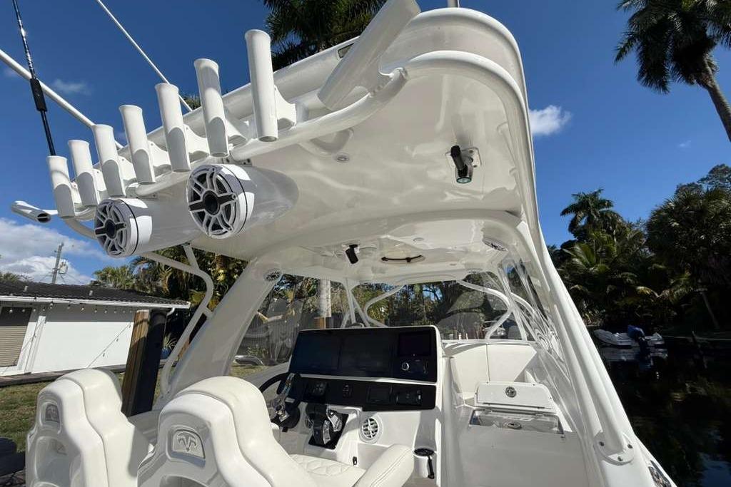 2008 Hydra-Sports Vector 3500 VX boat interior with rod holders and speakers, under a clear blue sky.