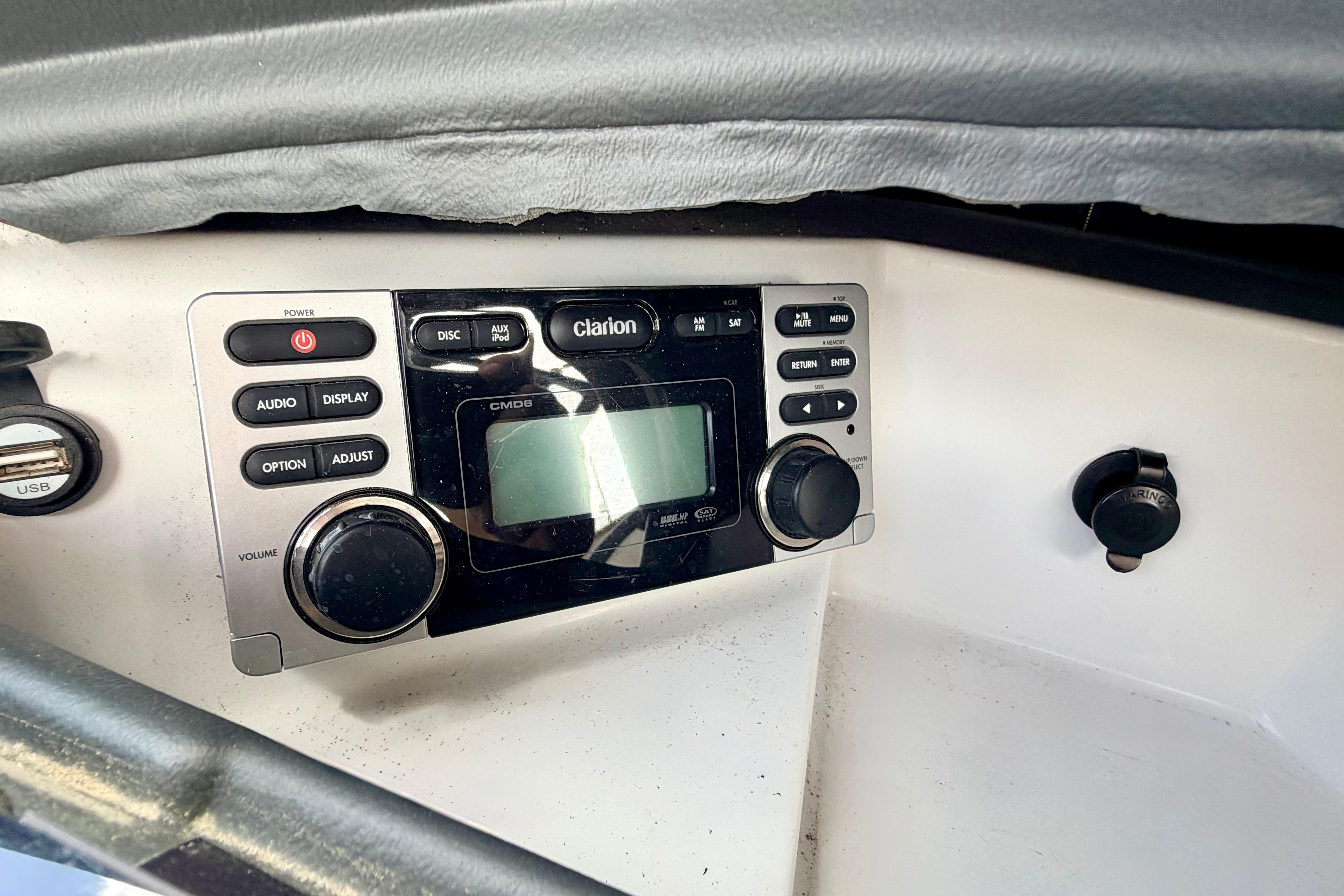 Clarion audio system in 2014 Tigé R20 boat dashboard, featuring control knobs and display.