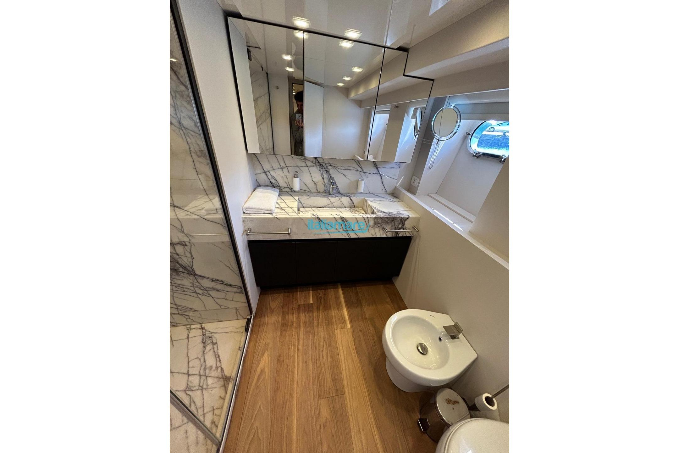Luxurious bathroom on 2009 PerMare Amer 92 yacht with marble accents and wooden flooring.
