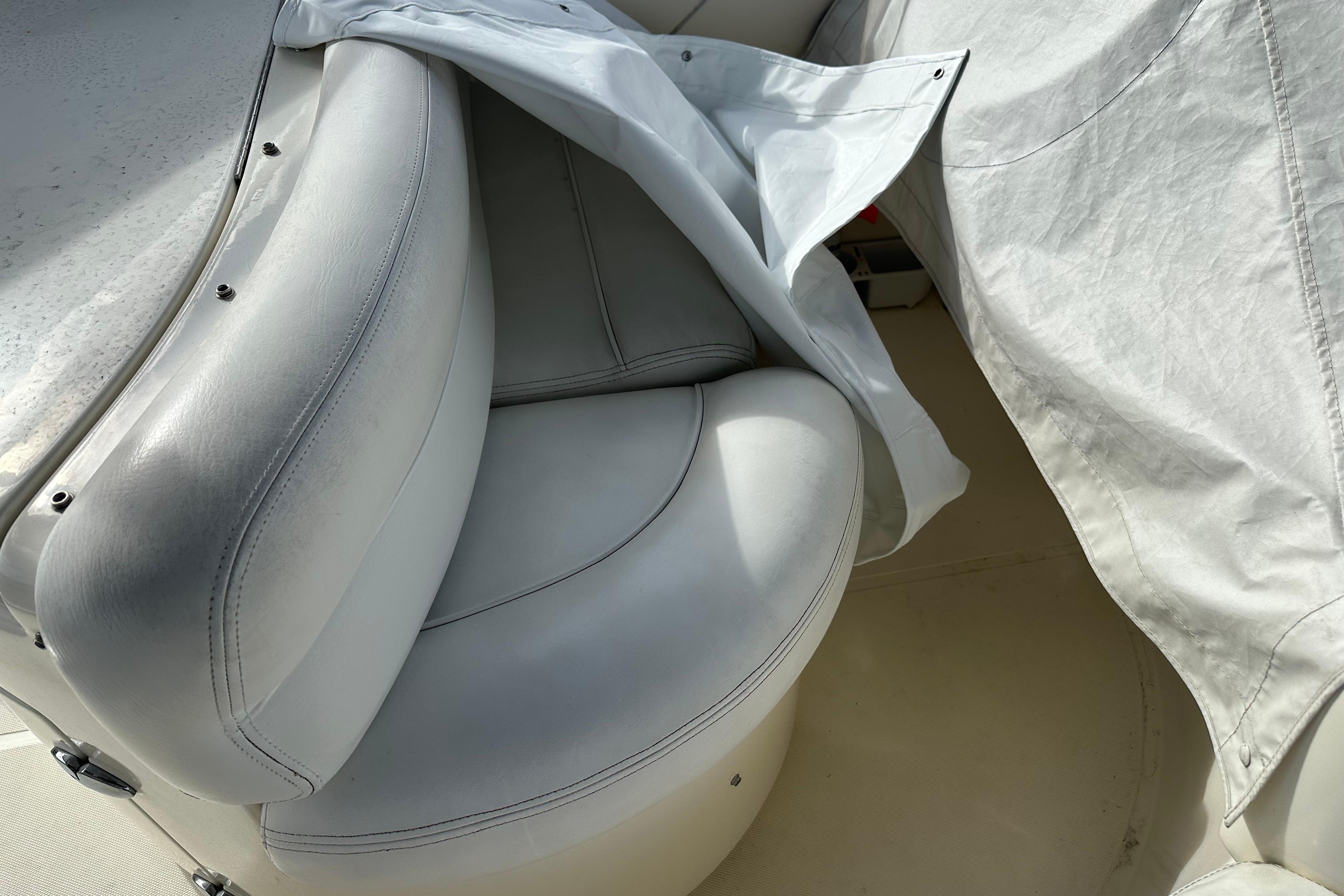 White leather seating on a 2004 Azimut 55E yacht, partially covered.