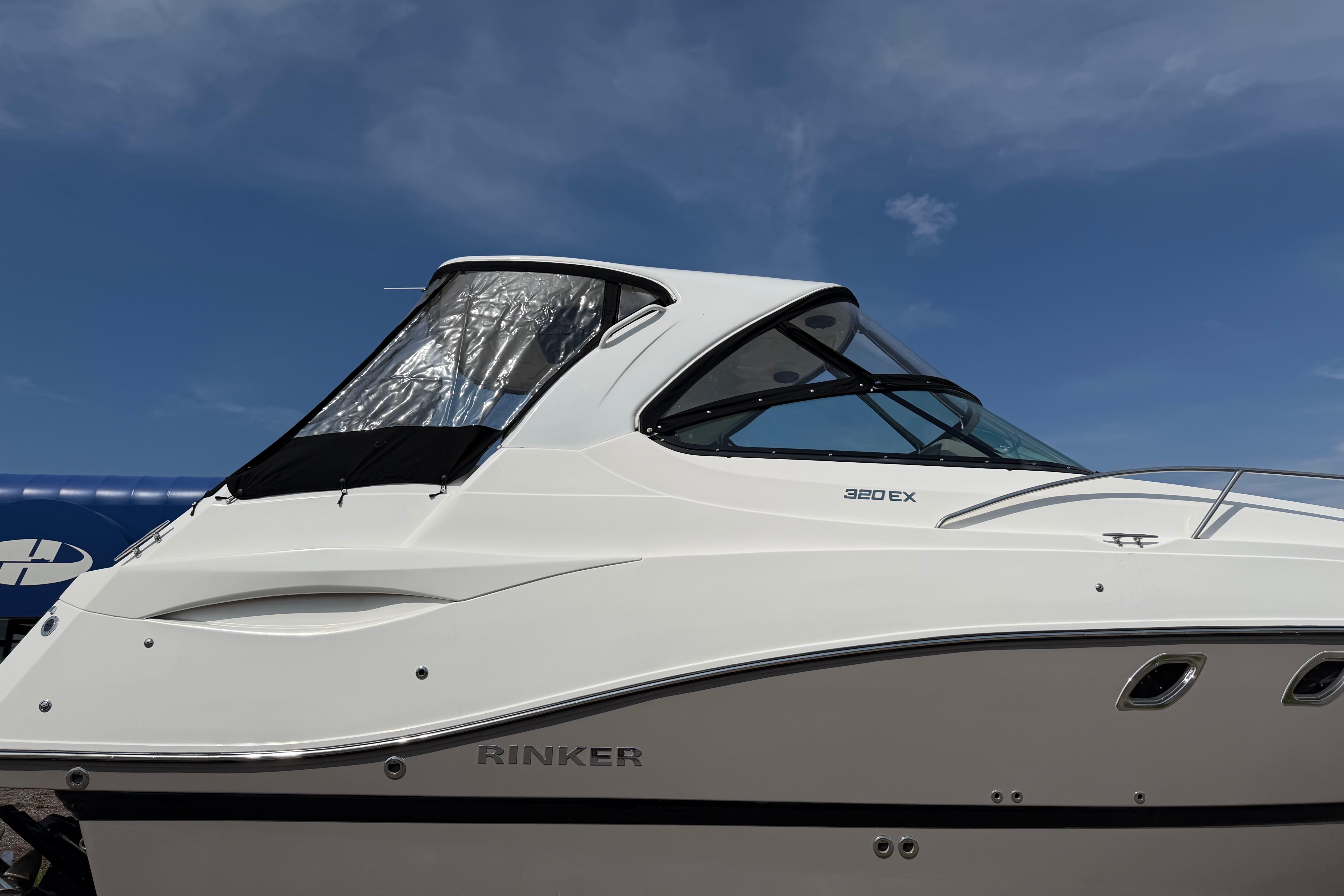 2019 Rinker EX 320 boat with sleek design against a clear blue sky.