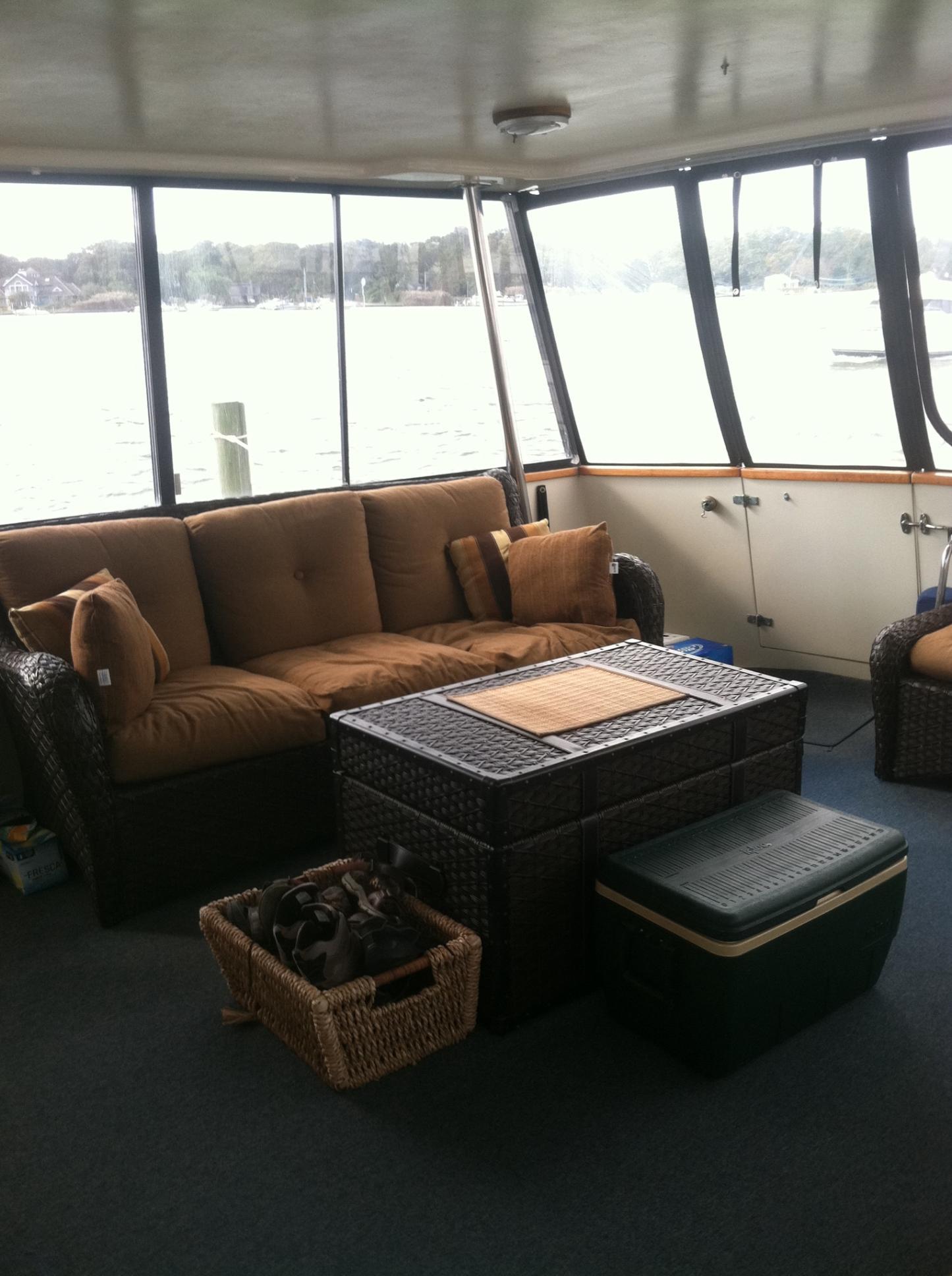 Interior of 1989 Californian 48 Motor Yacht with cozy seating and wicker furniture.