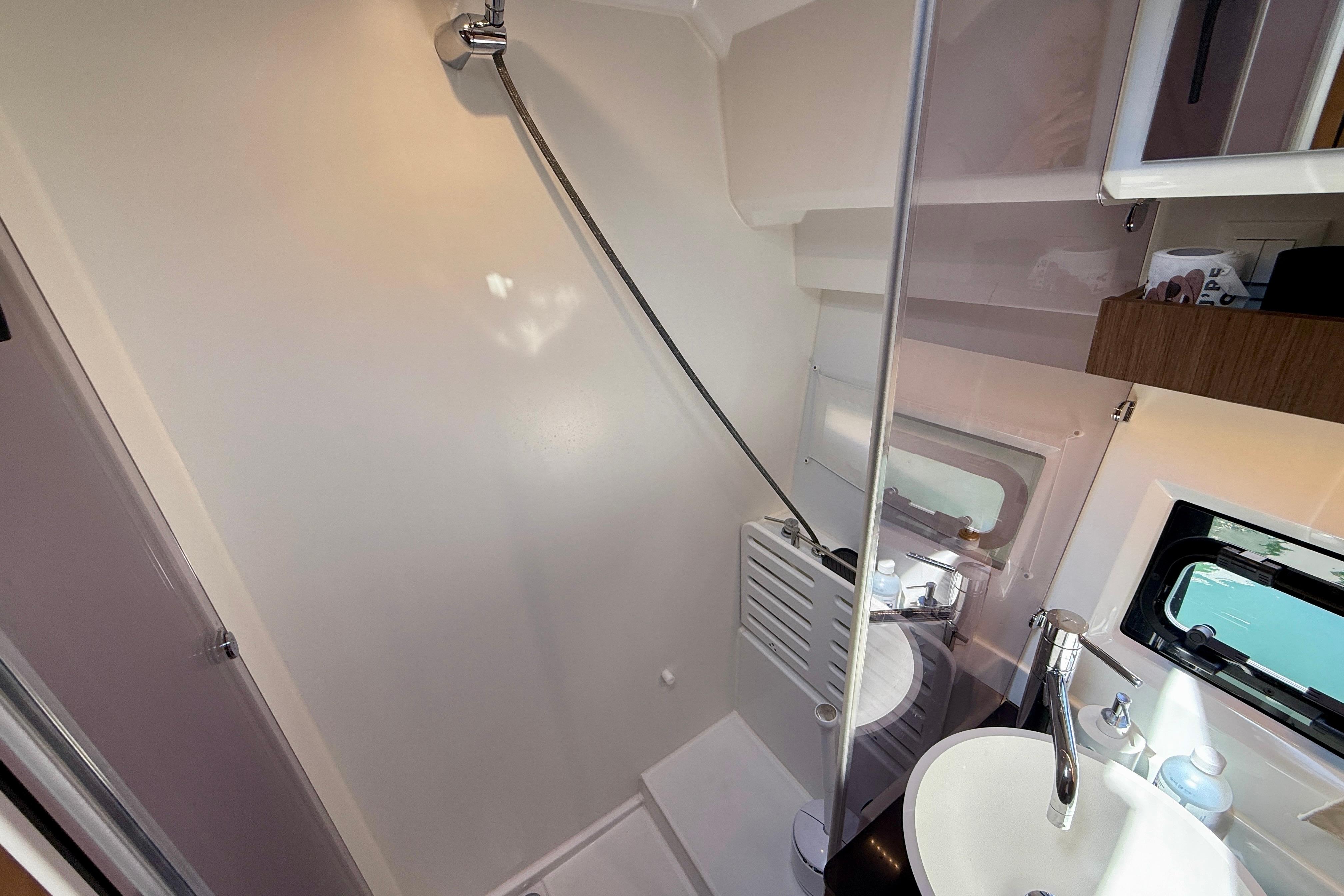 2022 Jeanneau NC 1095 Fly bathroom with shower, sink, and window.