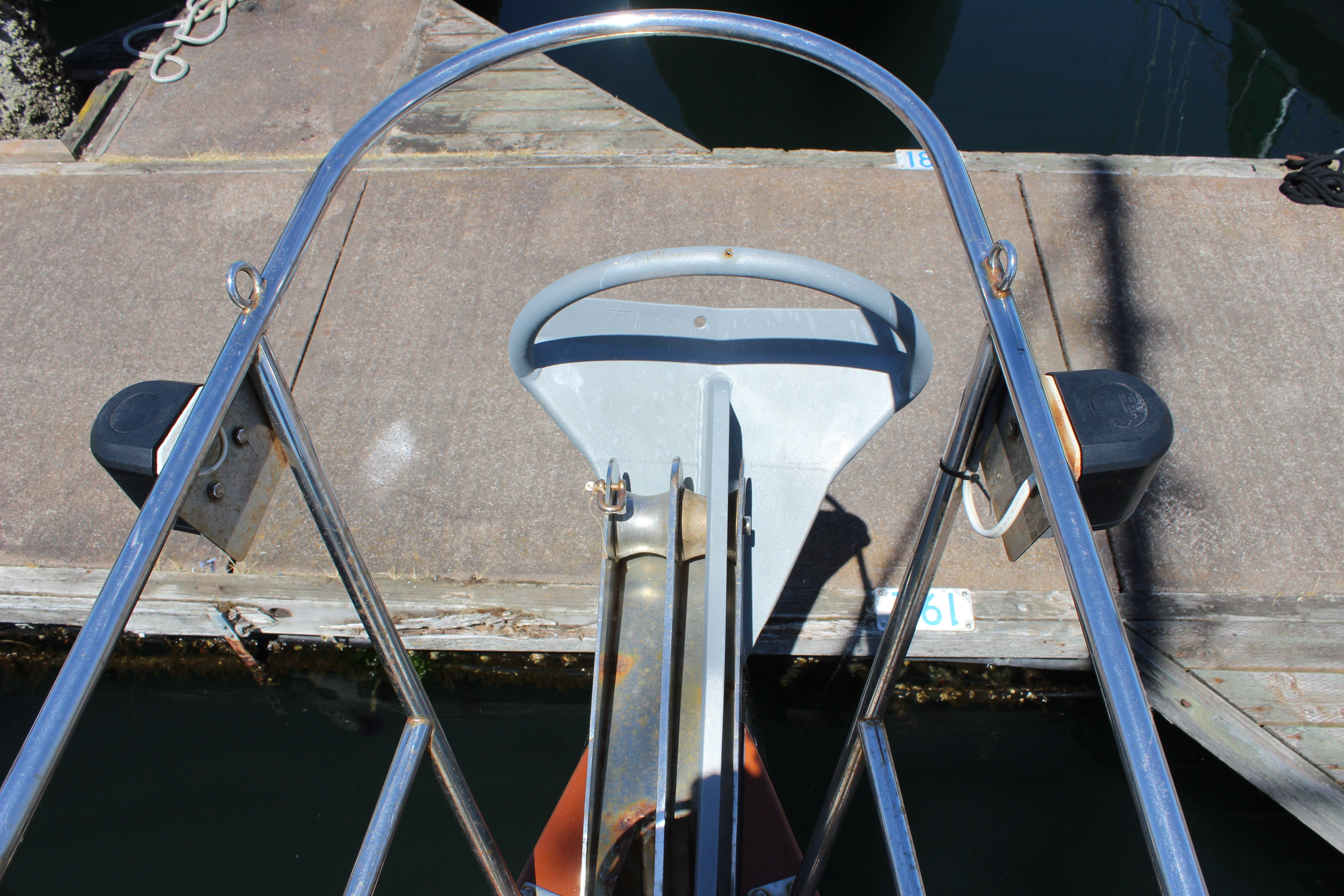 Bow view of 1981 Kelly Peterson 46 sailboat at dock, featuring anchor and railing.