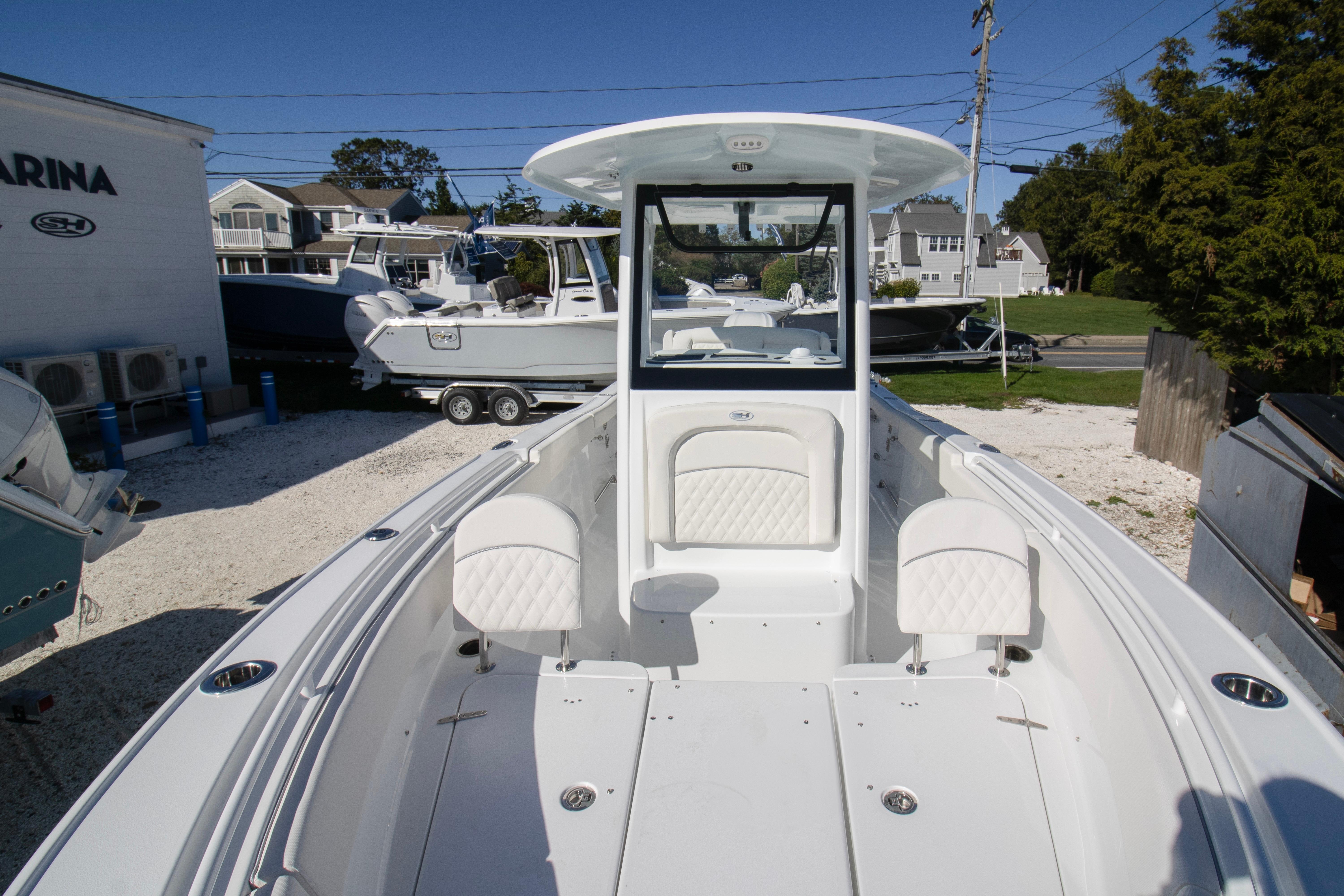 2026 Sea Hunt Ultra 255 SE boat docked at a marina under clear blue skies.