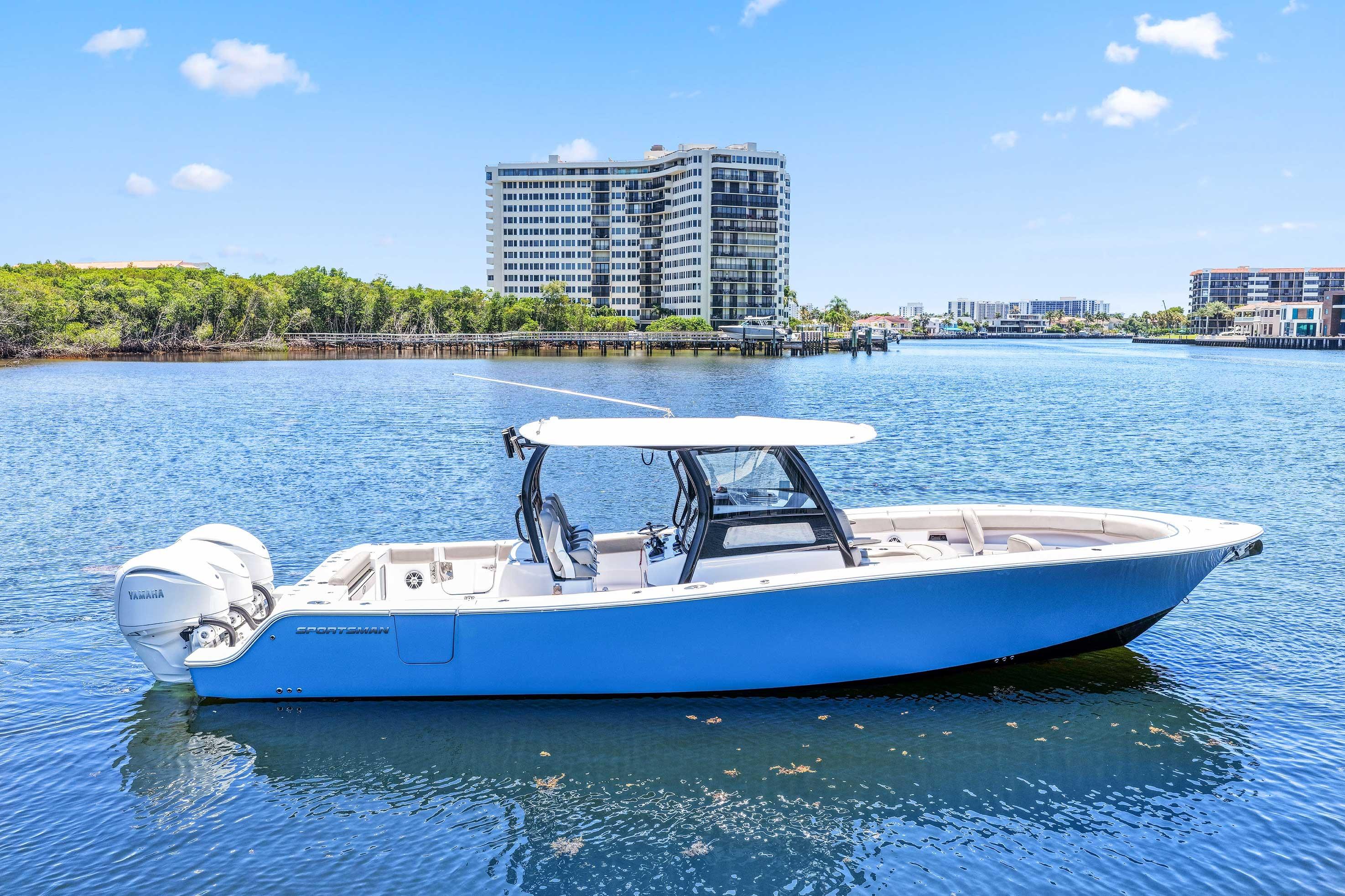 2024 Sportsman Open 352 Center Console boat on calm water, with cityscape background.
