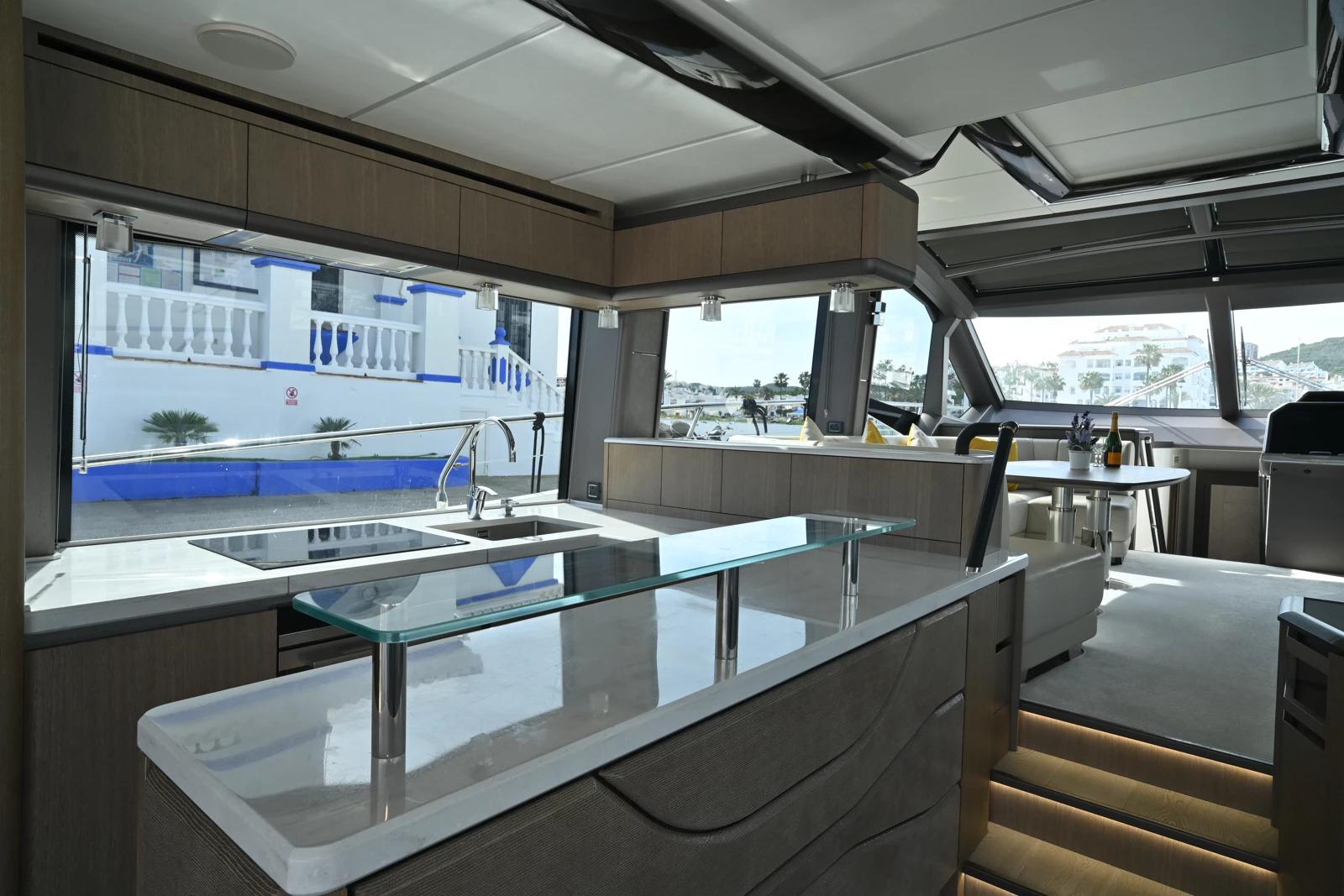 Luxurious interior of 2021 Galeon 680 Fly yacht with modern kitchen and seating area.